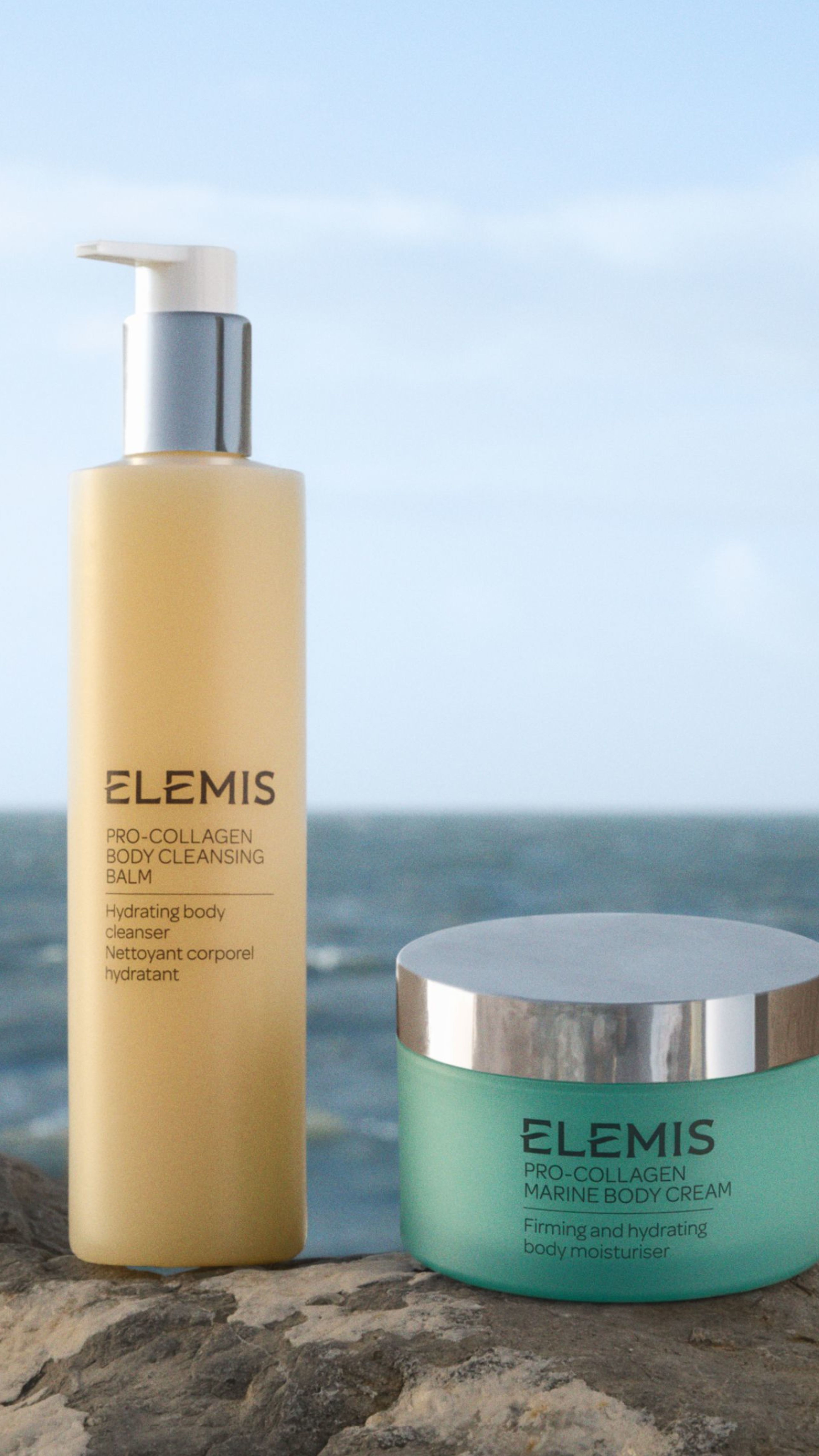 Elemis Pro-Collagen Body Cleansing Balm and Marine Body Cream on a rock by the ocean.