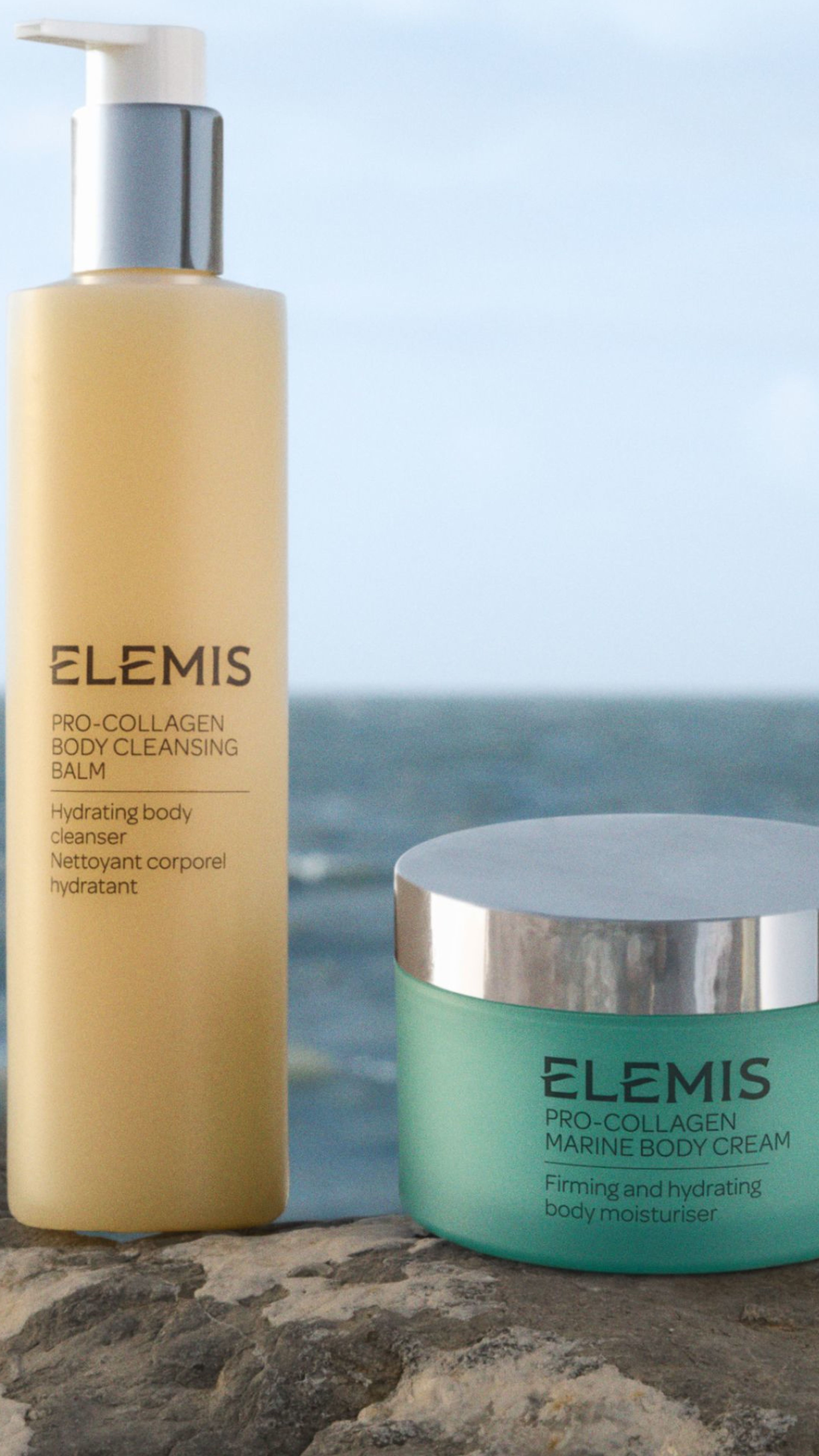 Elemis Pro-Collagen Body Cleansing Balm and Marine Body Cream on a rock by the ocean.