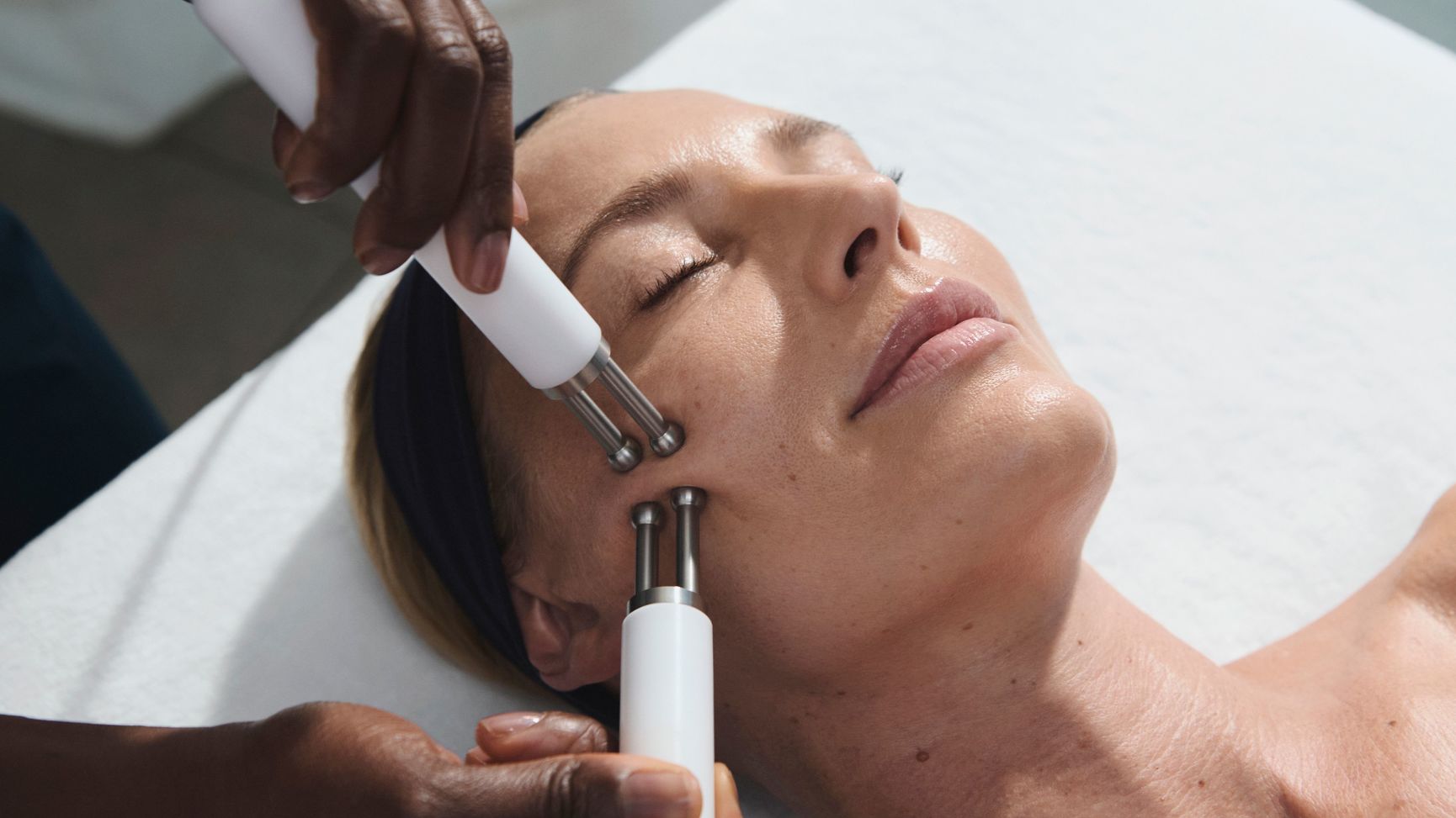 Mujer recibiendo un tratamiento facial de microcorriente.