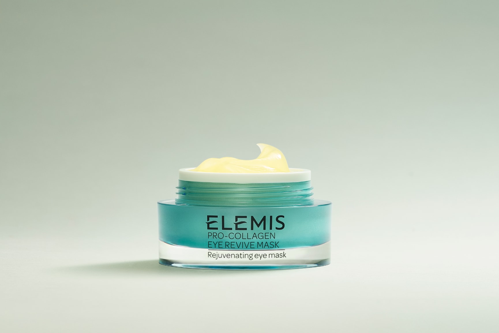 Two teal and silver Elemis Pro-Collagen eye products, an eye mask and an eye cream, sit in splashing water.
