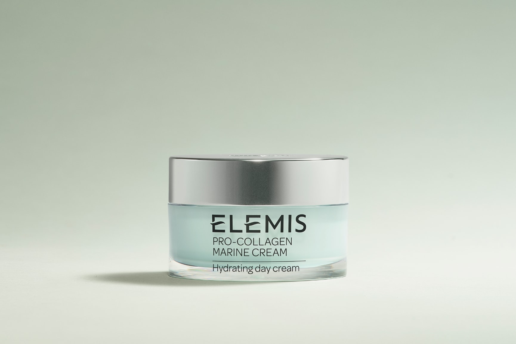 Two stacked Elemis Pro-Collagen cream jars underwater with bubbles.