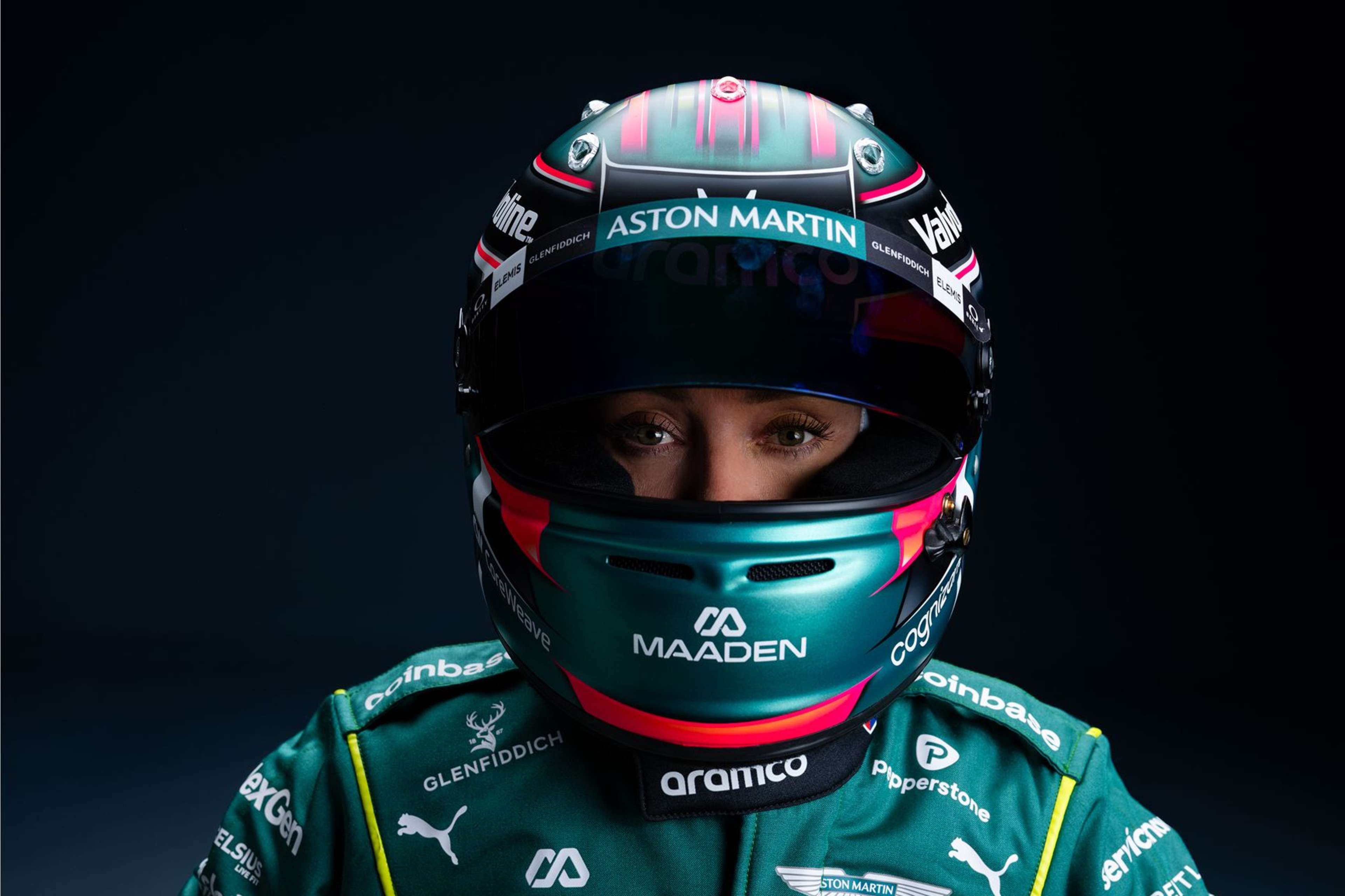 Teal Aston Martin Formula 1 car #18 speeds on a track.