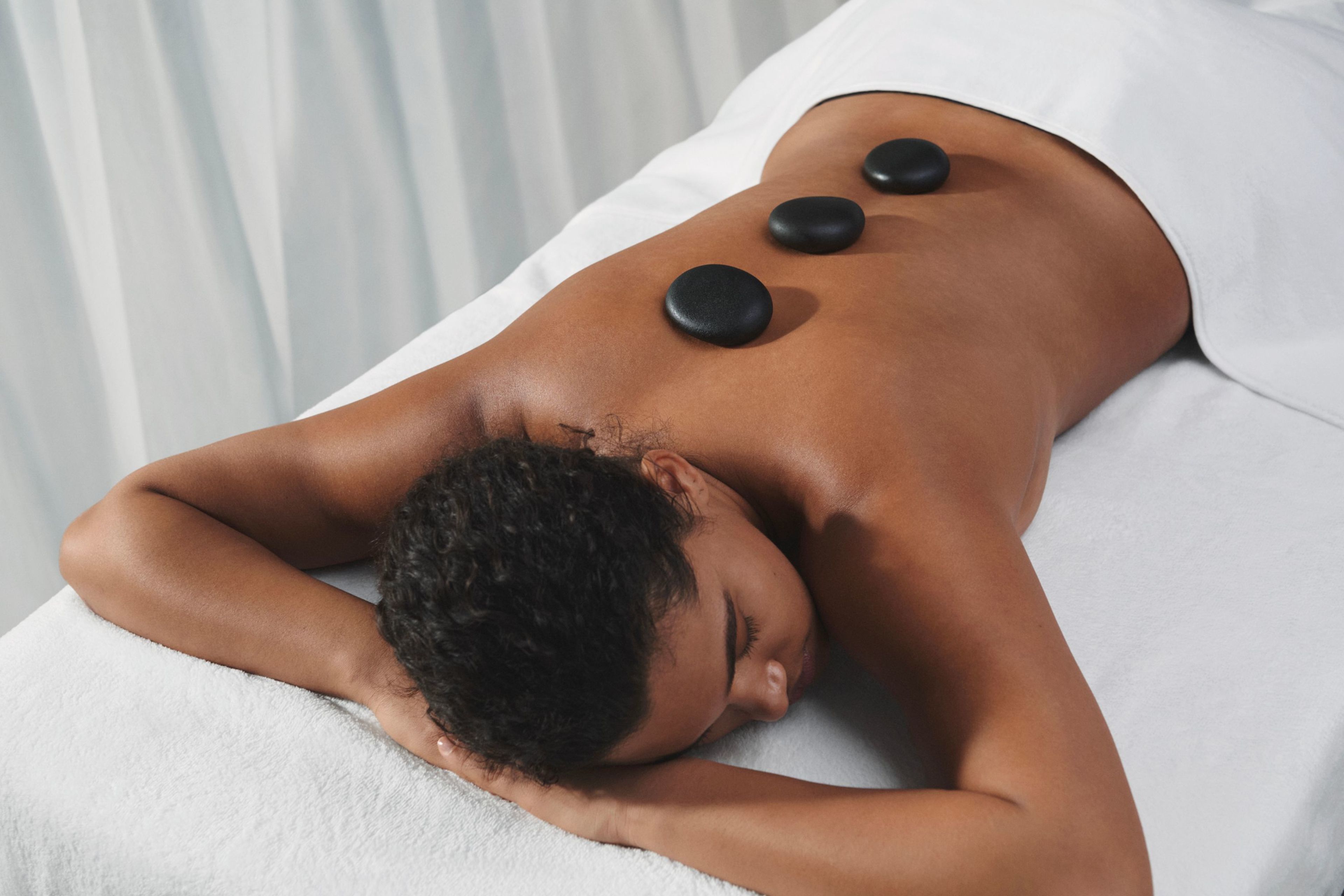A man receives a back massage on a massage table.