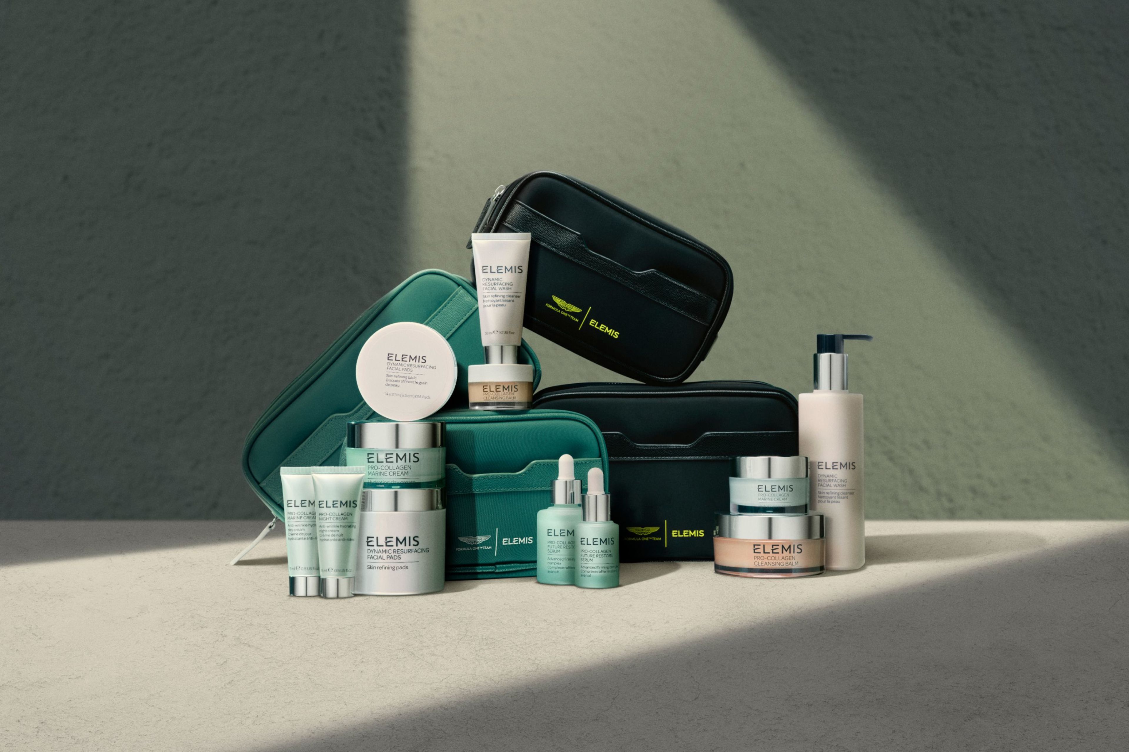 Elemis skincare products and teal and black travel bags, some featuring an Aston Martin logo.