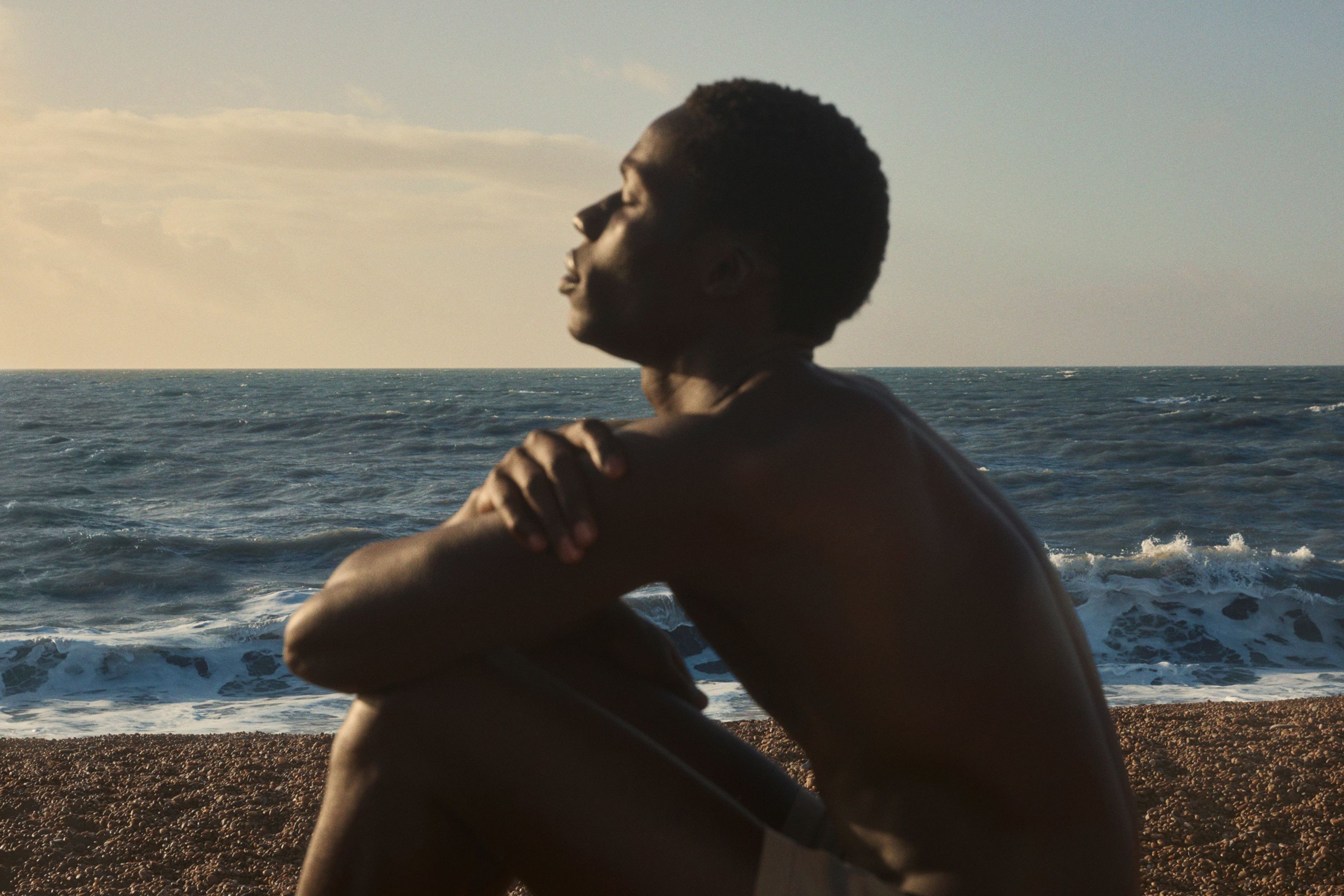 Man sitting by the sea eyes closed in the sun