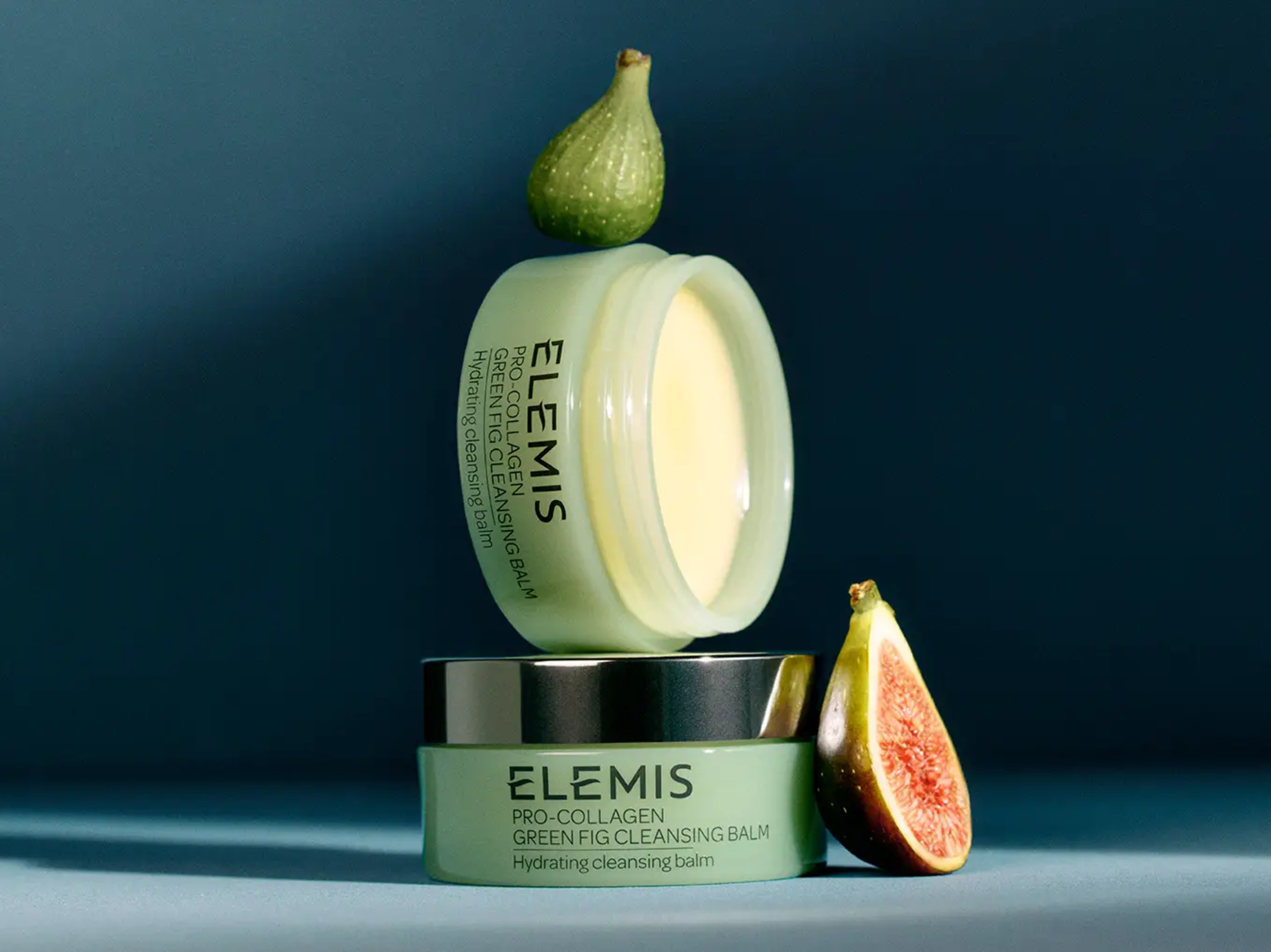 Due balsami detergenti Pro-Collagen Green Fig di ELEMIS, uno aperto e sovrapposto a uno chiuso, con fichi interi e tagliati a metà.