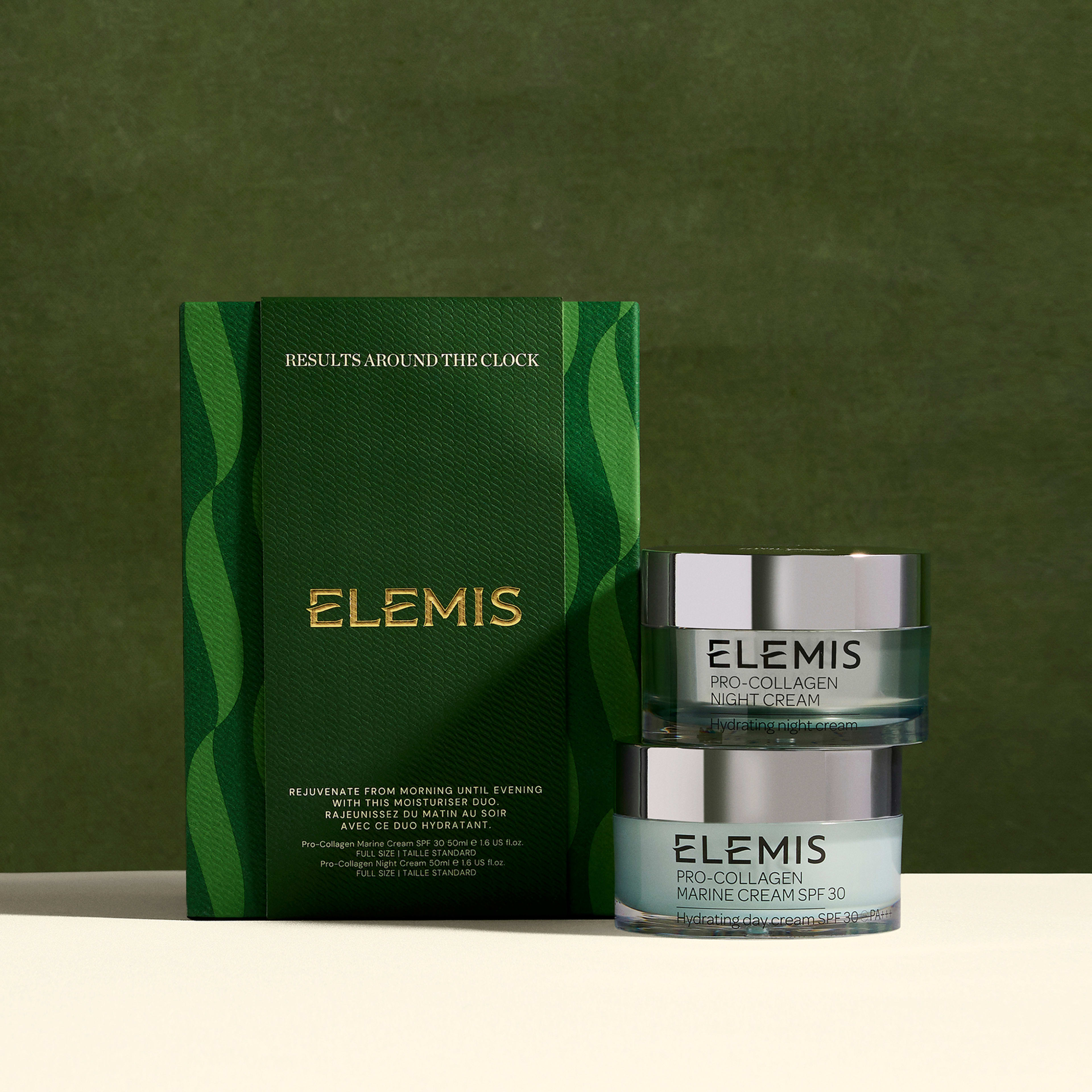 ELEMIS Pro-Collagen skincare gift set against a green background, featuring a tall green box reading “RESULTS AROUND THE CLOCK” and “ELEMIS” beside two stacked jars labelled Pro-Collagen Night Cream and Pro-Collagen Marine Cream SPF 30.