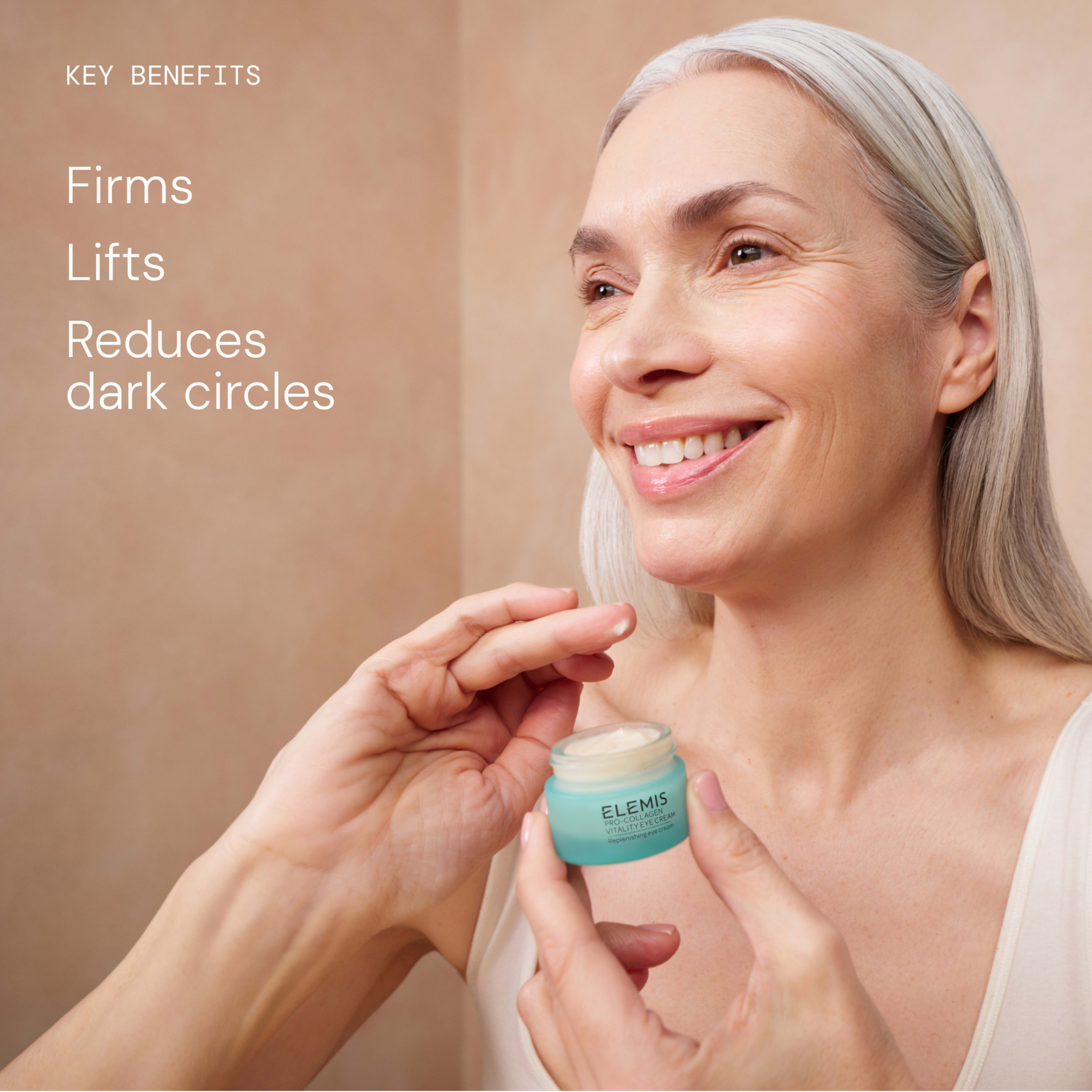 Smiling mature woman having ELEMIS eye cream applied from a small turquoise jar. On the left, text reads “Key benefits: Firms, Lifts, Reduces dark circles”.