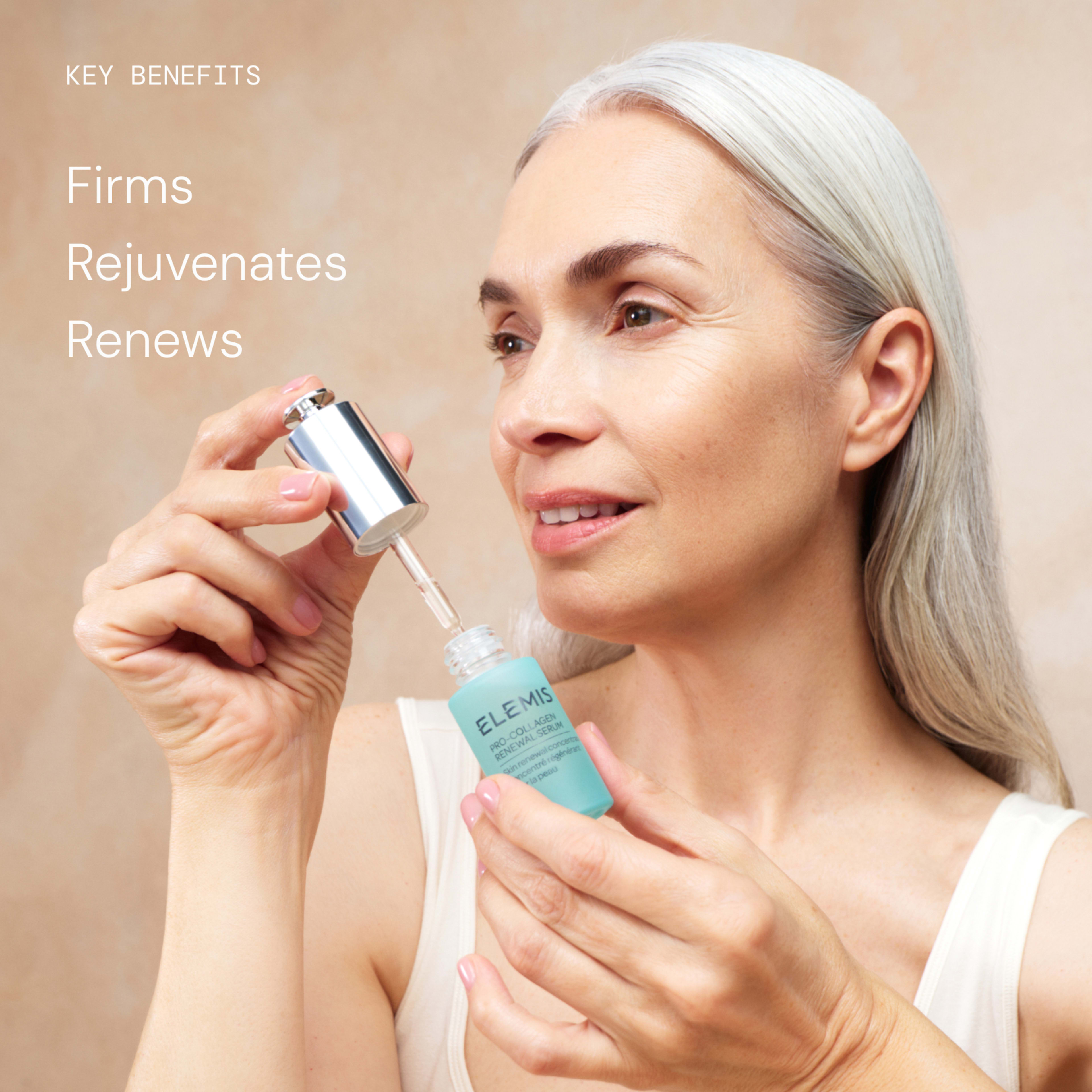 Smiling older woman with long grey hair applies ELEMIS Pro-Collagen Renewal Serum from a dropper bottle. On the left, text reads: “Key benefits: Firms, Rejuvenates, Renews.”