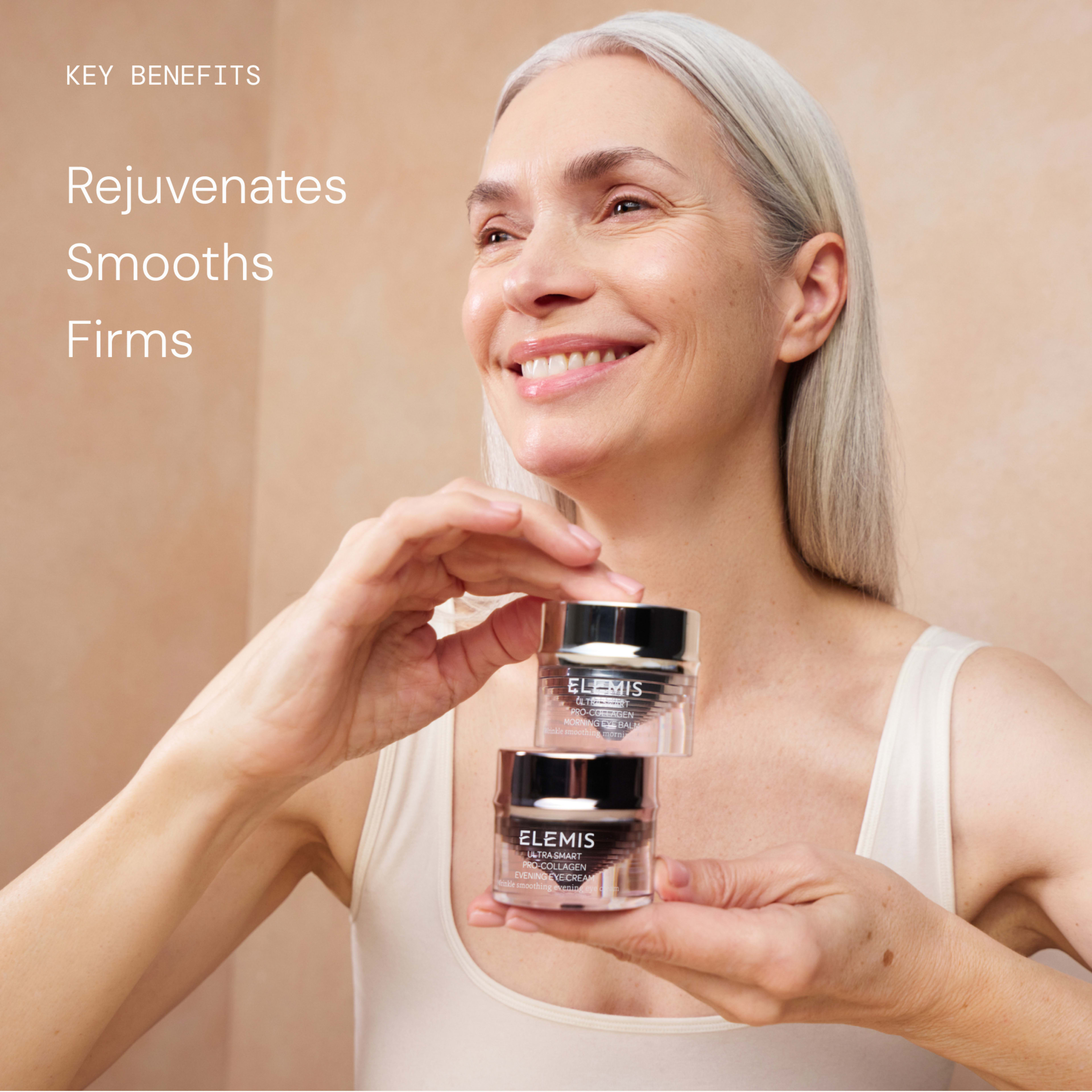 Smiling woman with grey hair holds two ELEMIS Advanced Skincare moisturiser jars against a soft beige background. On the left, text reads: “Key benefits: rejuvenates, smooths, firms.”