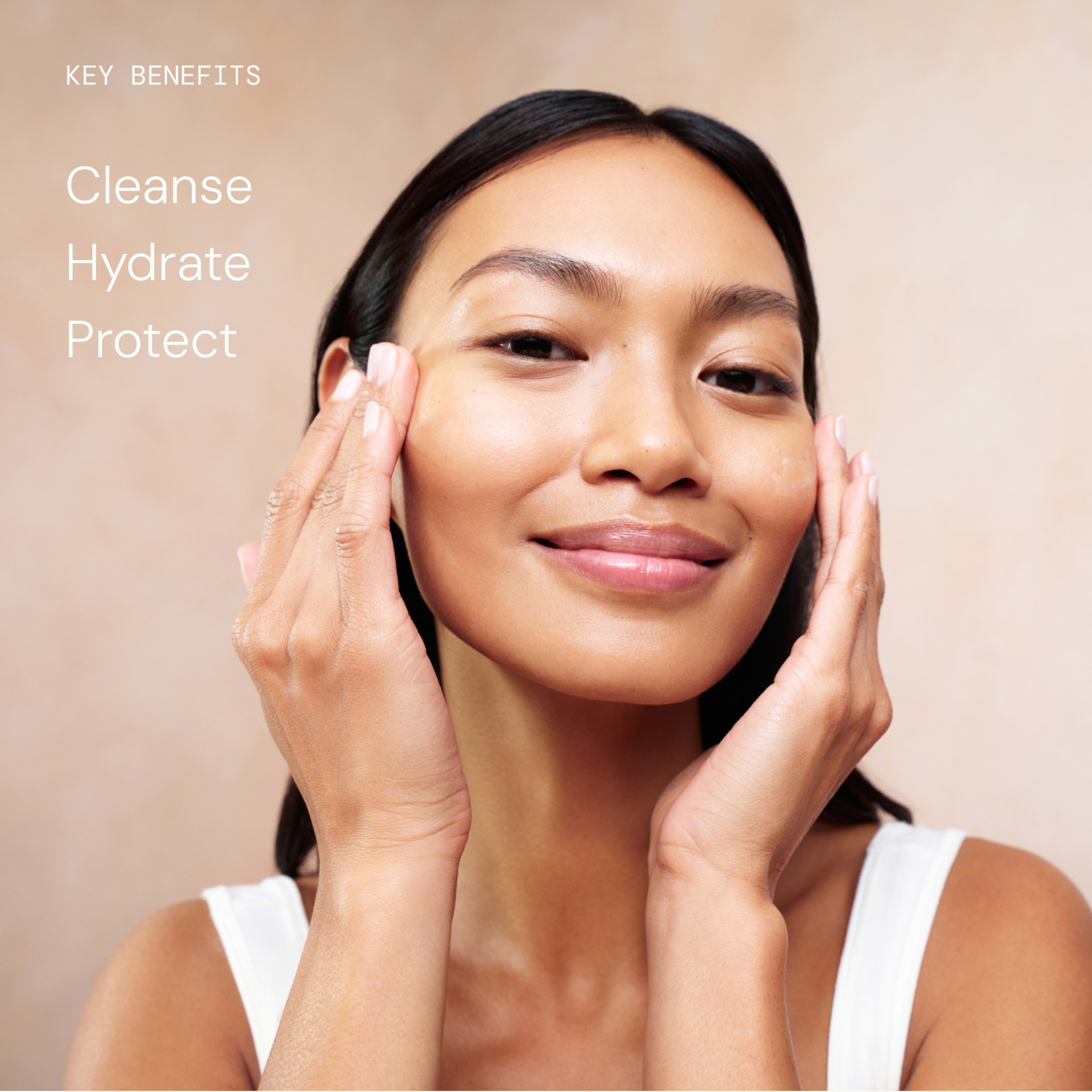 Woman gently massaging skincare into her cheeks and smiling, promoting a calm, hydrated complexion. On the left, text reads: “Key benefits: Cleanse, Hydrate, Protect.”