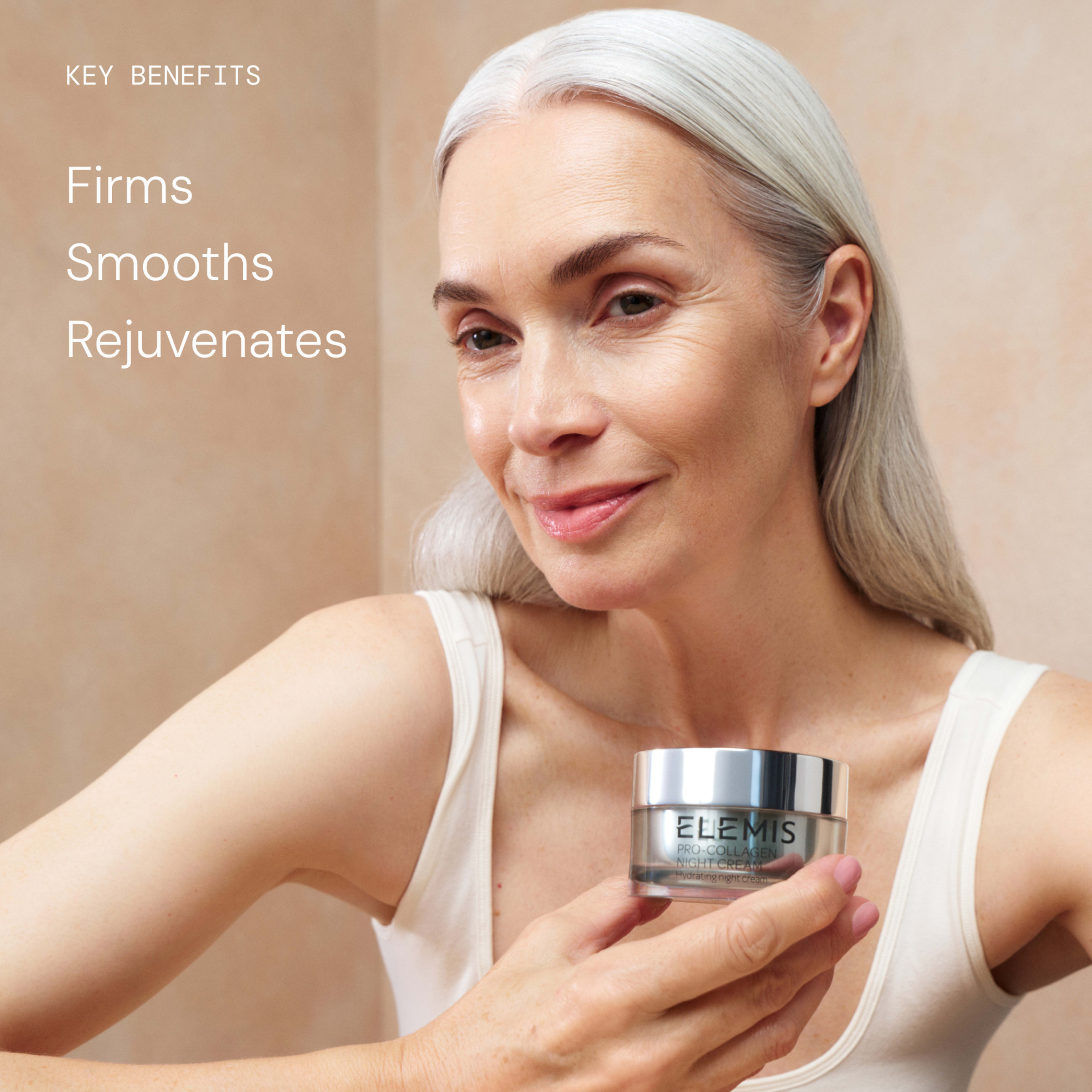 Smiling older woman with long grey hair holds a jar of ELEMIS Pro-Collagen Night Cream close to her face against a neutral background. On the left, text reads: "Key benefits: Firms, Smooths, Rejuvenates."