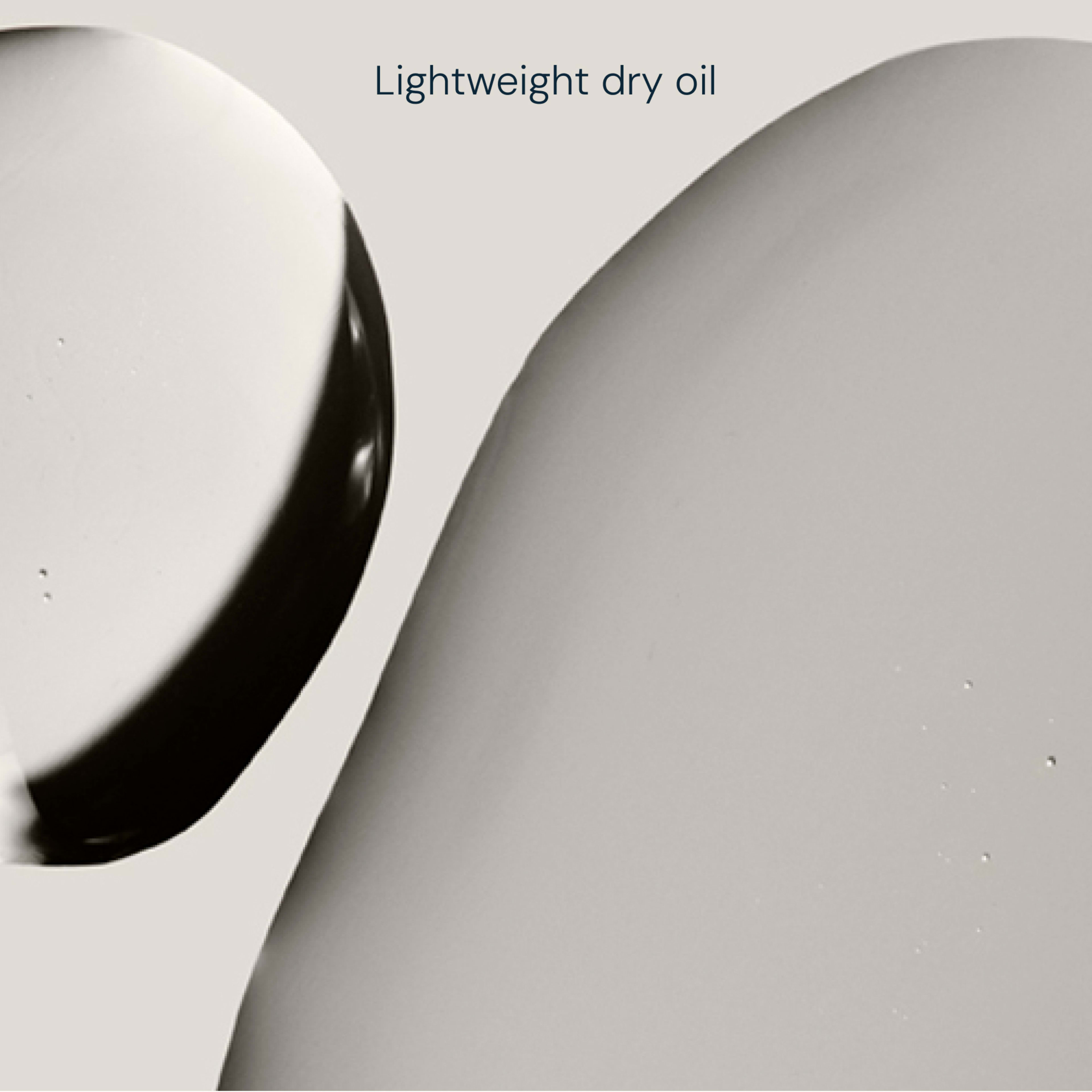 Abstract close-up of two overlapping pale grey oil swatches on a neutral background with the text “Lightweight dry oil” centred at the top.