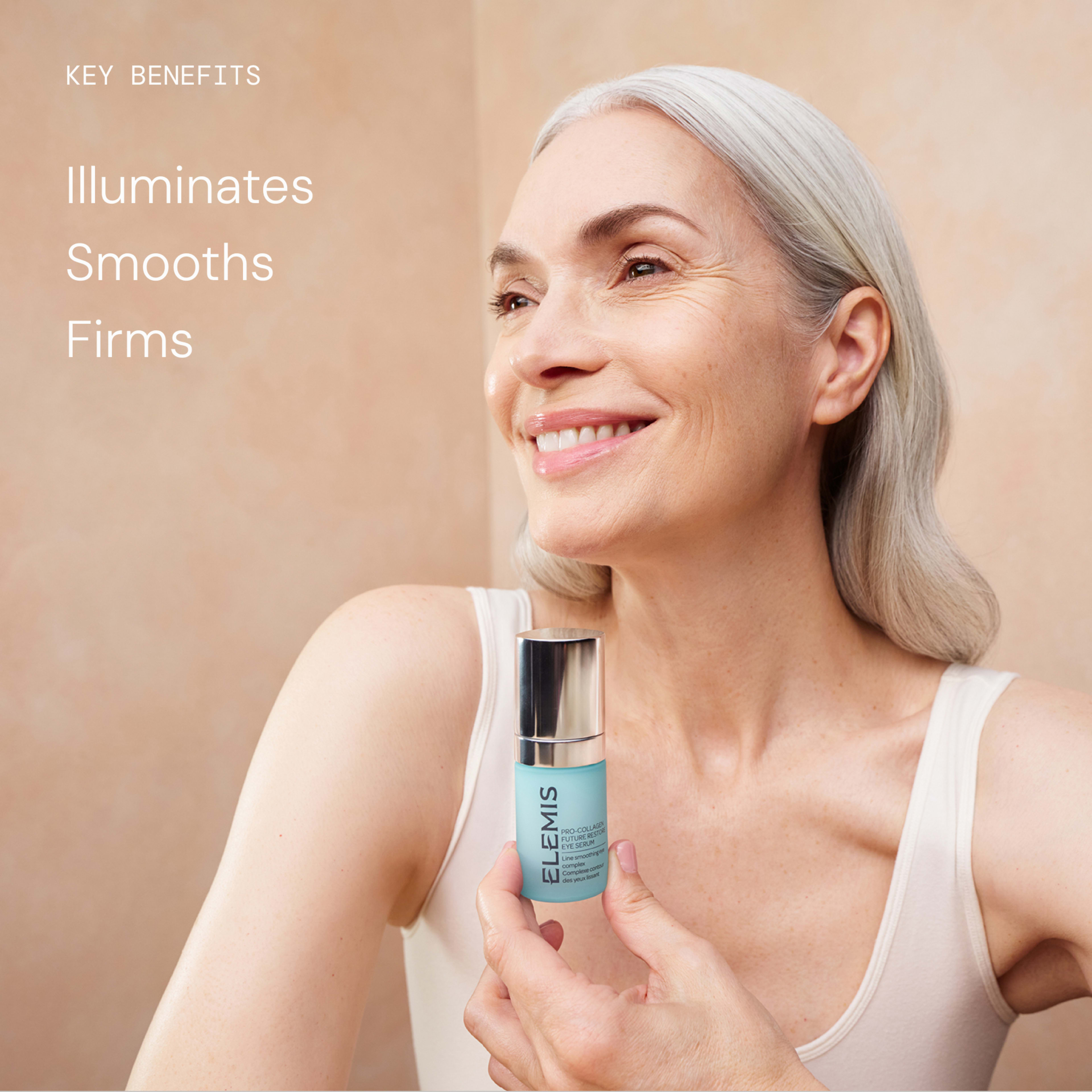 Smiling older woman with long grey hair holds a bottle of ELEMIS skincare serum against a neutral background. Text beside her reads: “Key benefits: Illuminates, Smooths, Firms.”