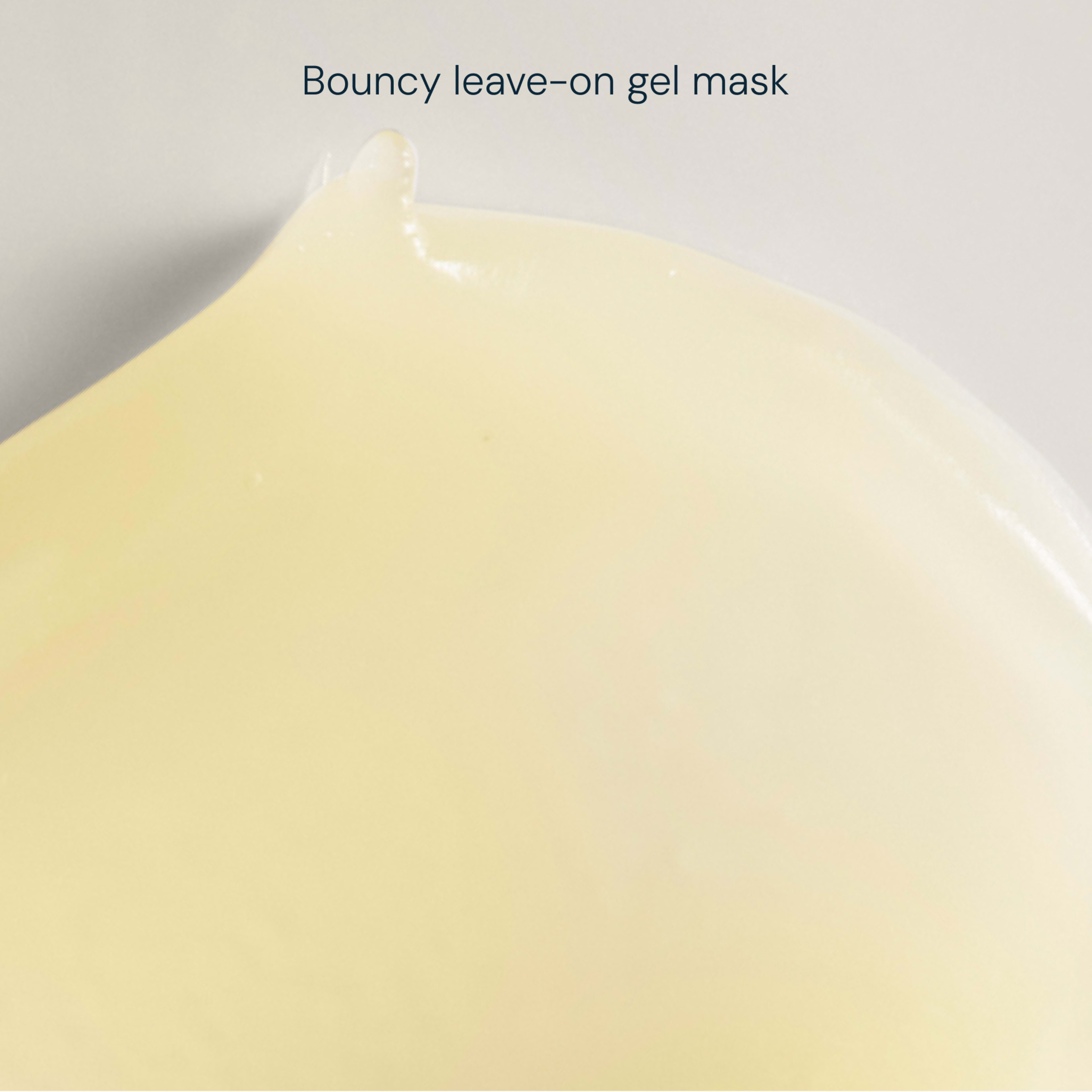 Close-up swatch of pale yellow gel with a glossy, bouncy texture, labelled “Bouncy leave-on gel mask”.