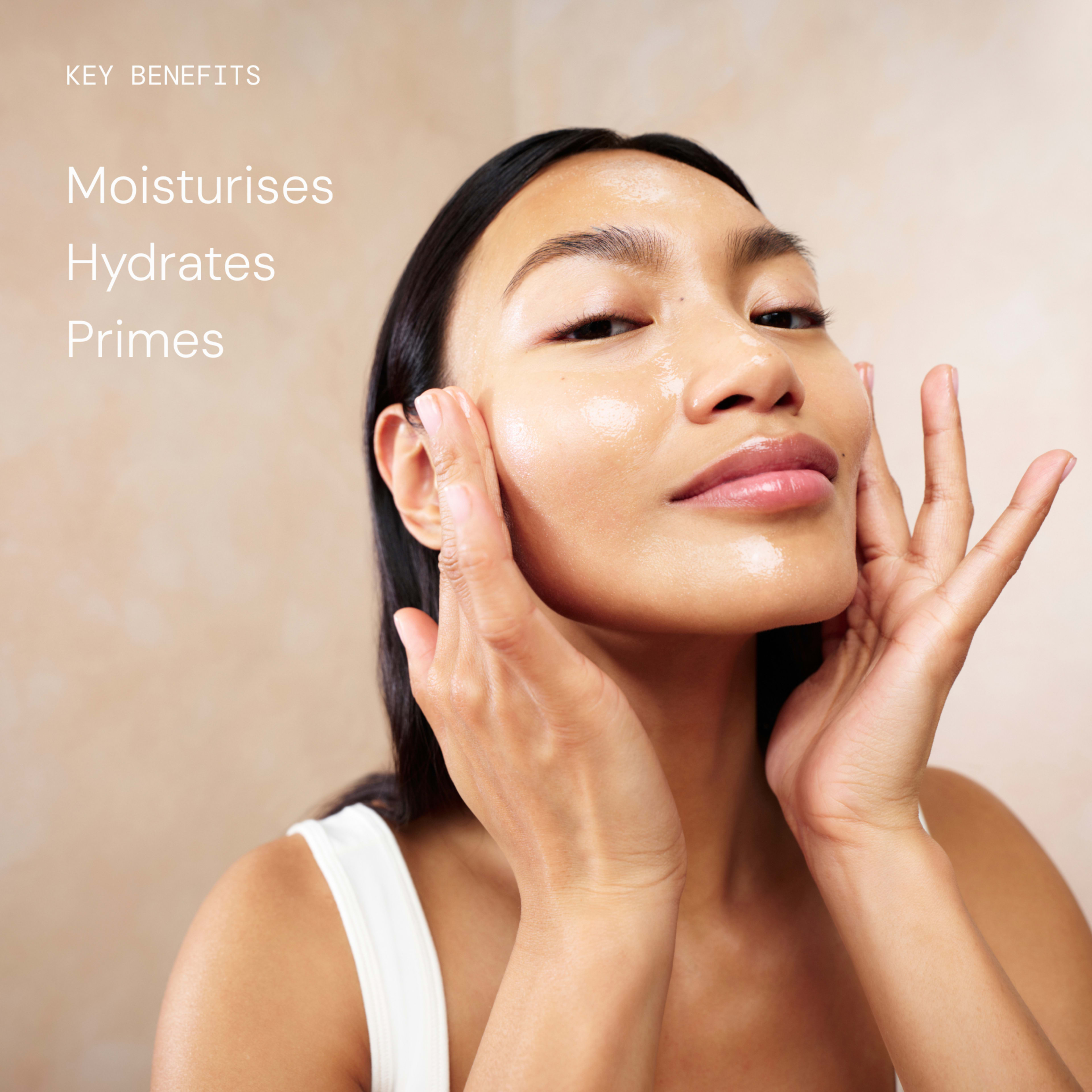 Woman massaging glowing skincare serum into her cheeks, looking towards the camera with relaxed expression. Text on the left reads: “Key benefits – Moisturises, Hydrates, Primes”.