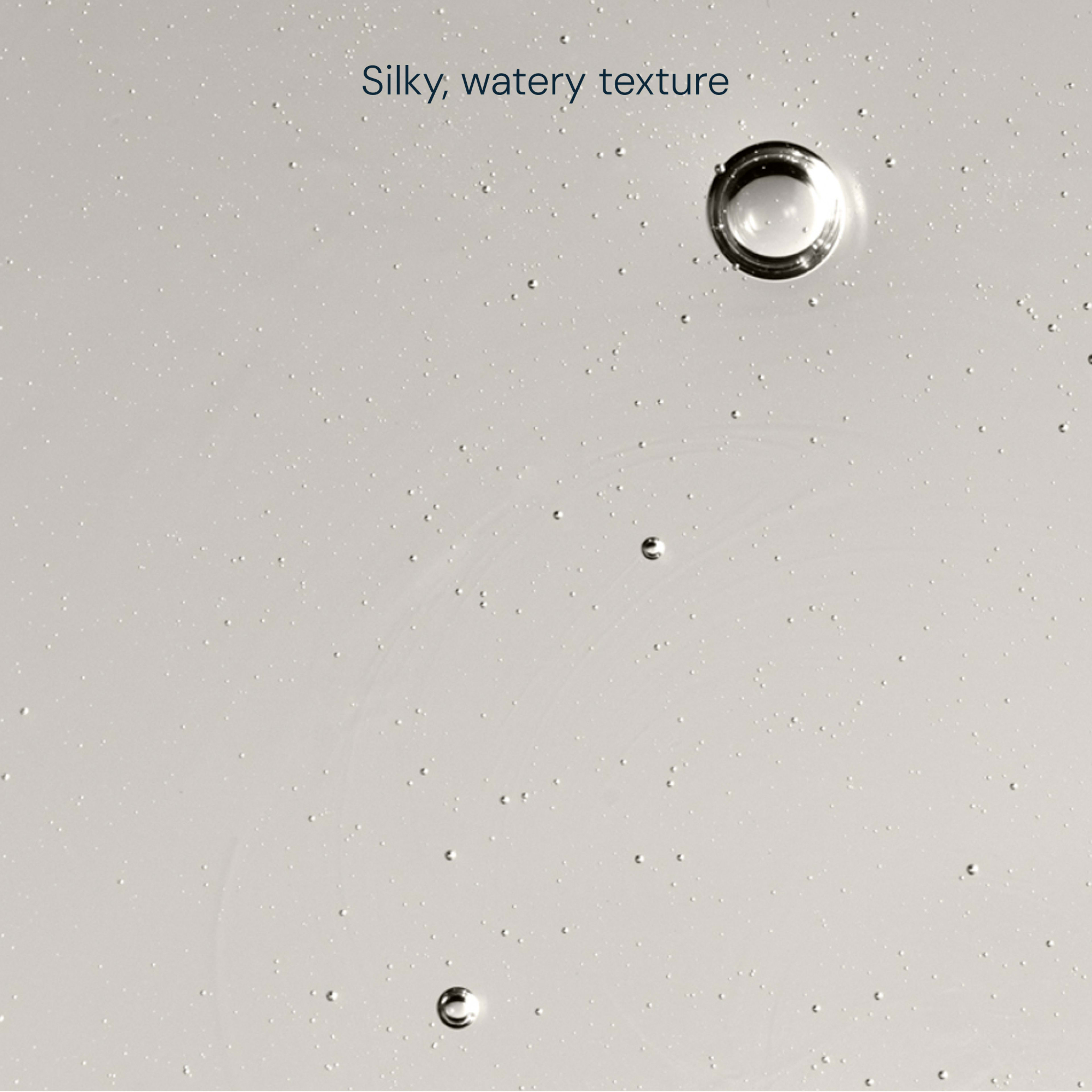 Close-up of clear liquid with scattered bubbles against a pale background, with the caption “Silky, watery texture” describing its smooth consistency.