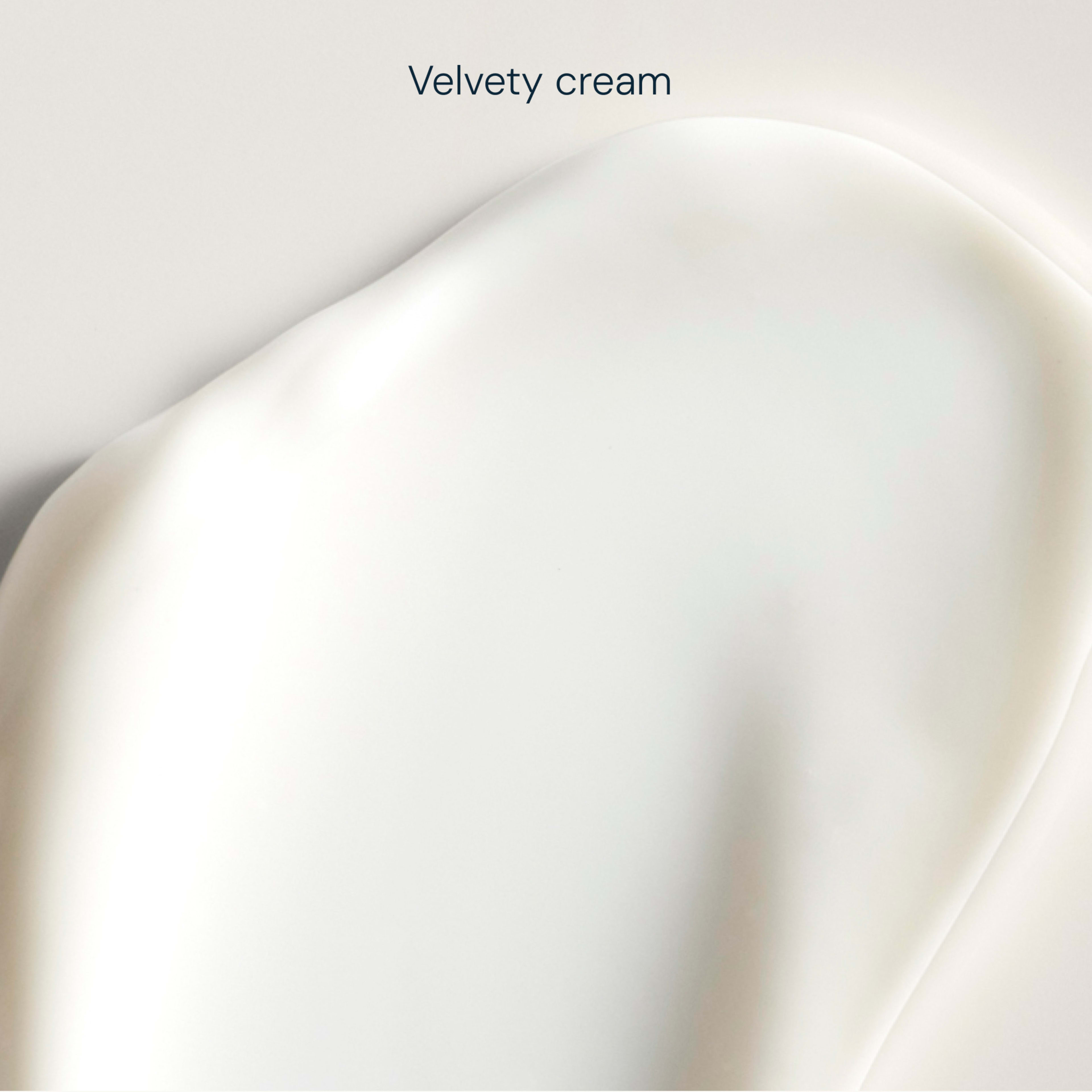 Close-up swatch of smooth white velvety cream on a pale background, with the words “Velvety cream” above.
