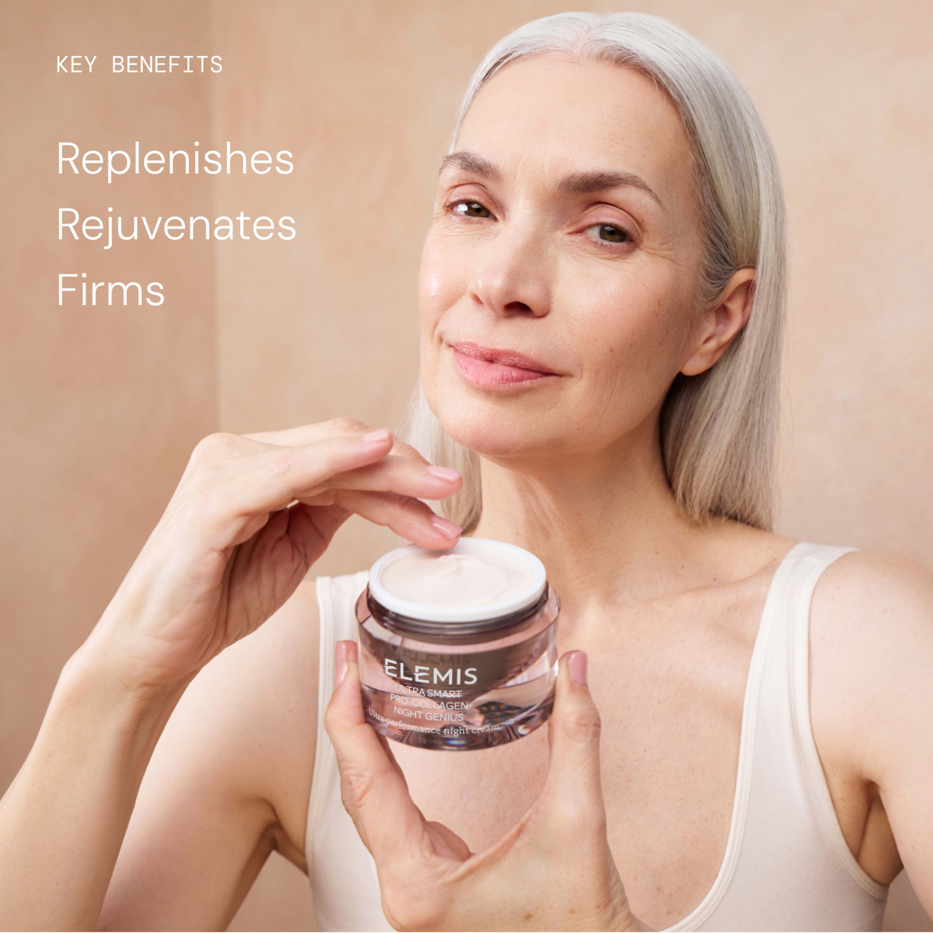 Smiling woman with long grey hair applies ELEMIS face cream from a jar, promoting skincare benefits. On-image text reads: "Key benefits: Replenishes, Rejuvenates, Firms."