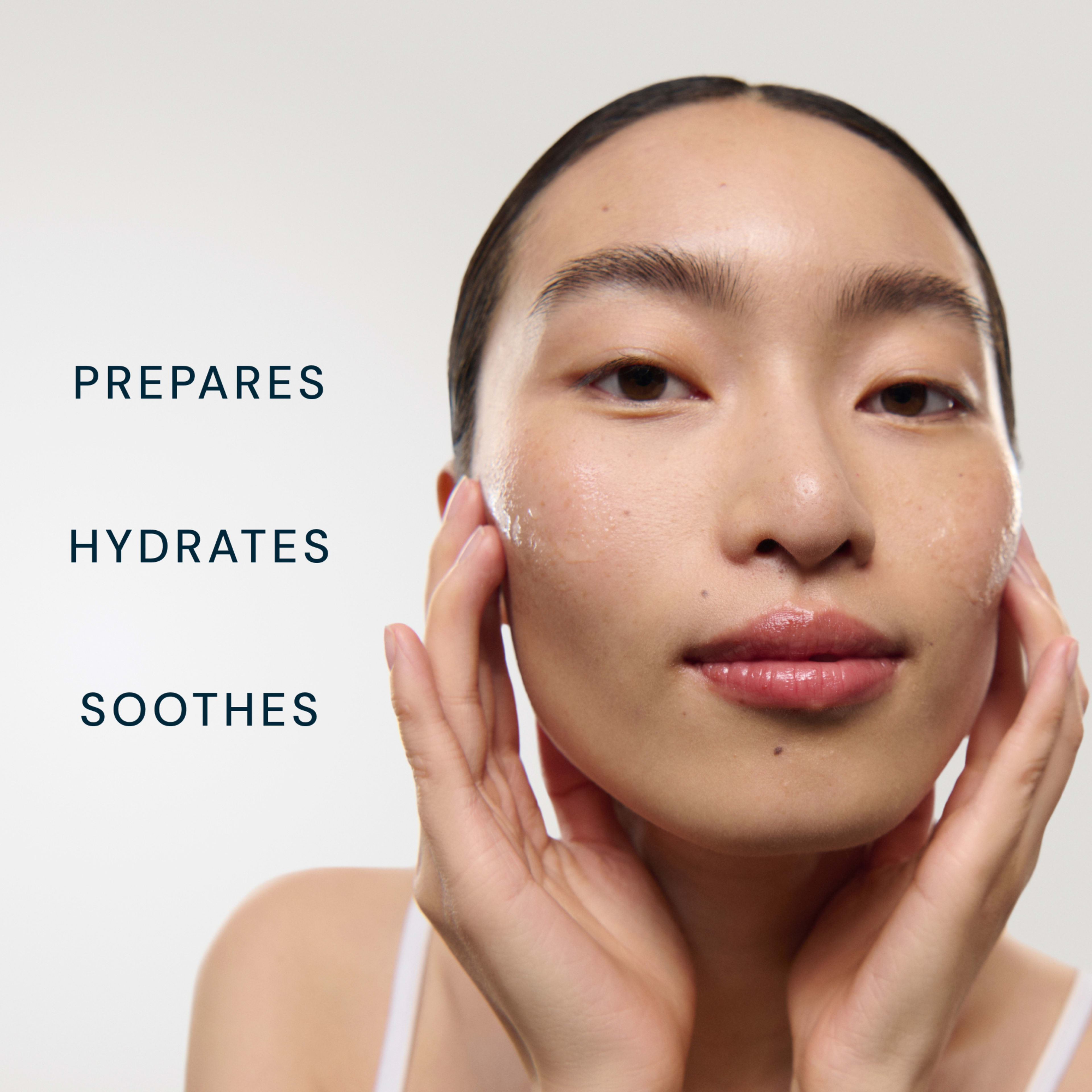 Close-up of a woman massaging skincare product into her face, with dewy skin and a calm expression. Text beside her reads: "PREPARES", "HYDRATES", "SOOTHES".