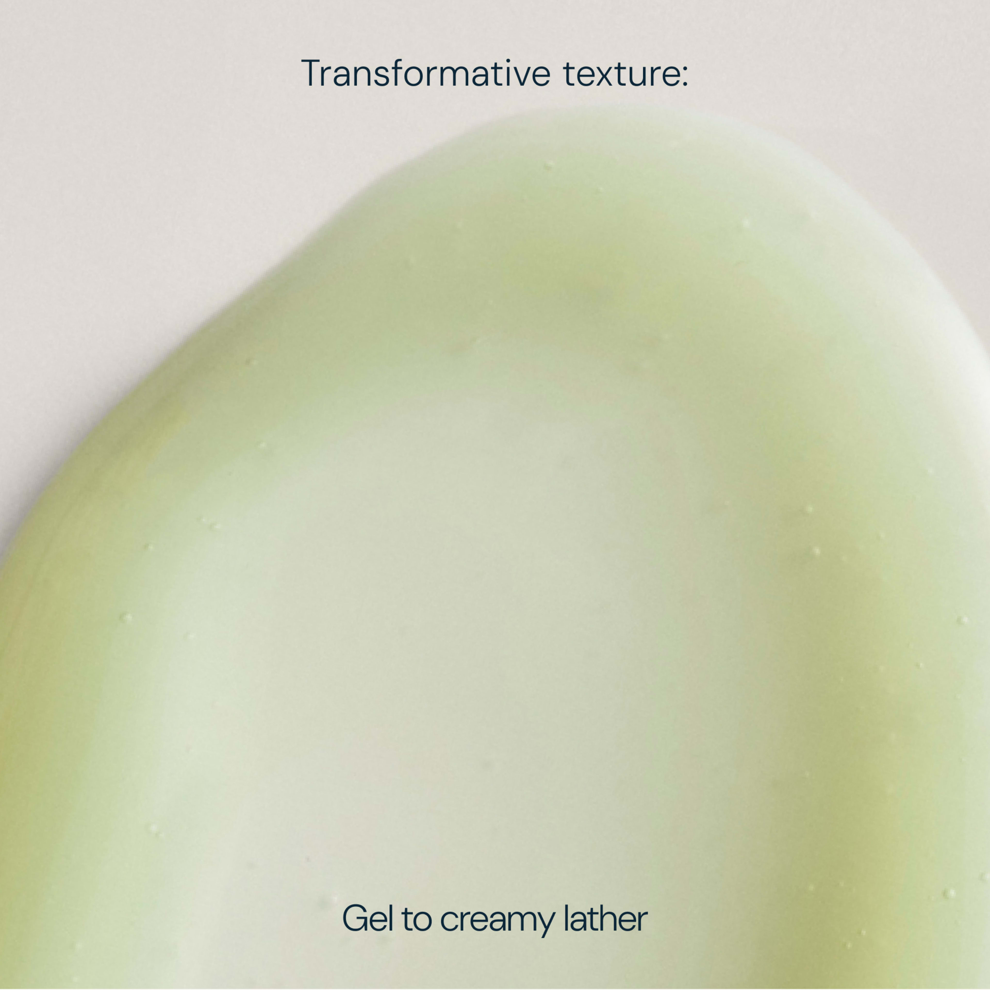 Soft green gel texture with smooth, glossy surface, overlaid text reading “Transformative texture: Gel to creamy lather”, illustrating a skincare product’s change from gel to foam.