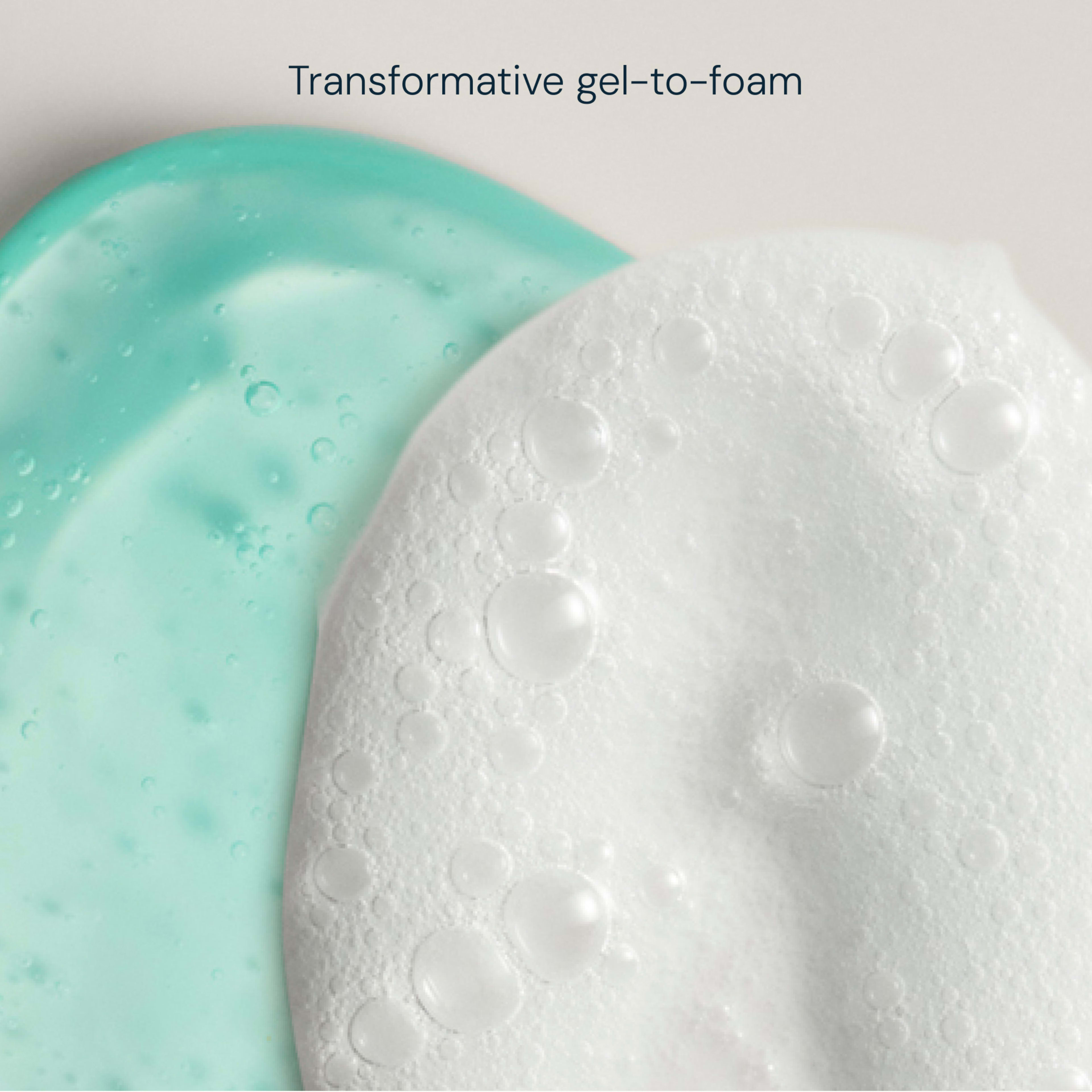 Overhead view of pale turquoise gel next to white foamy lather, illustrating a skincare product’s texture change with the caption “Transformative gel-to-foam”.