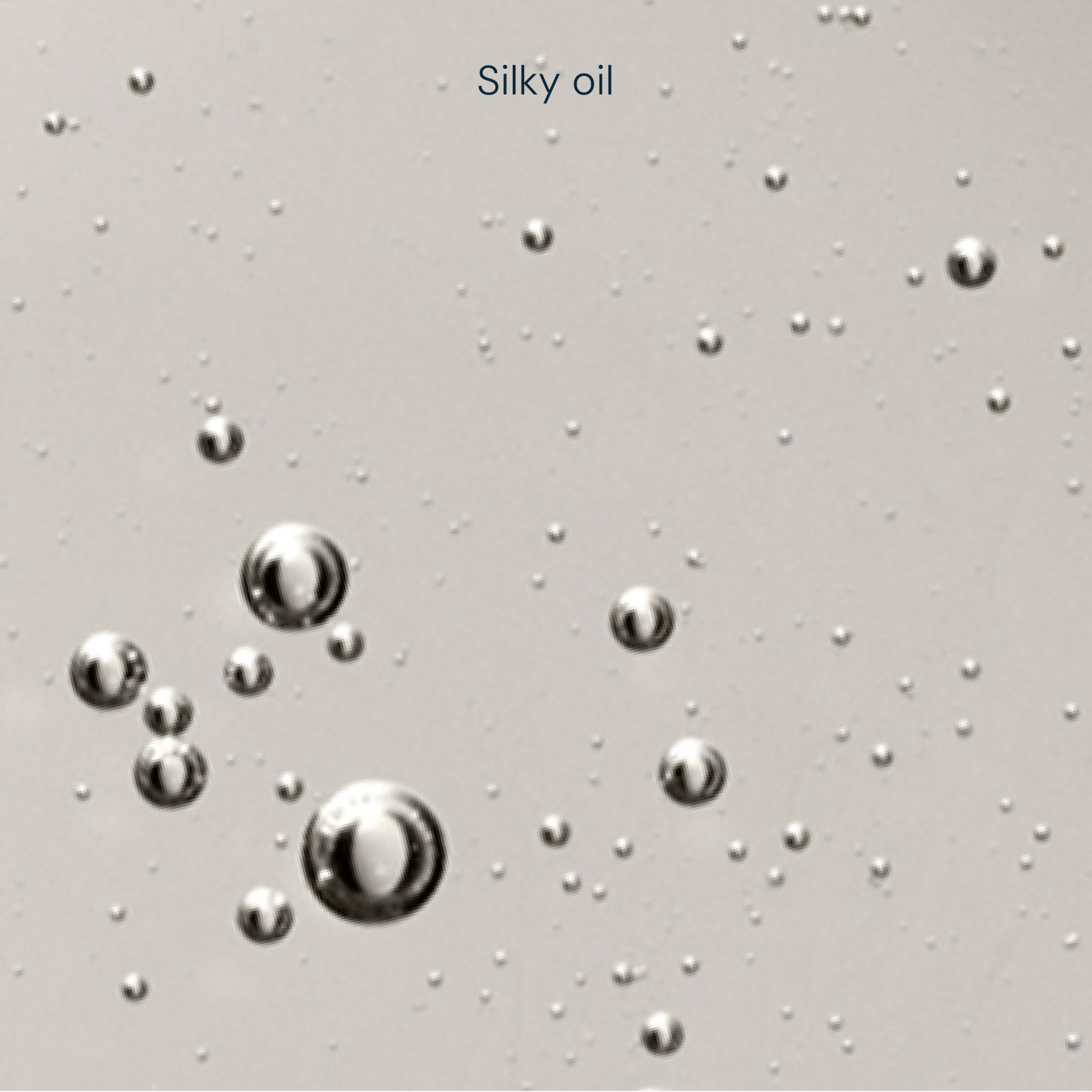 Close-up of clear, silky oil with suspended bubbles against a pale background, with the words "Silky oil" at the top.