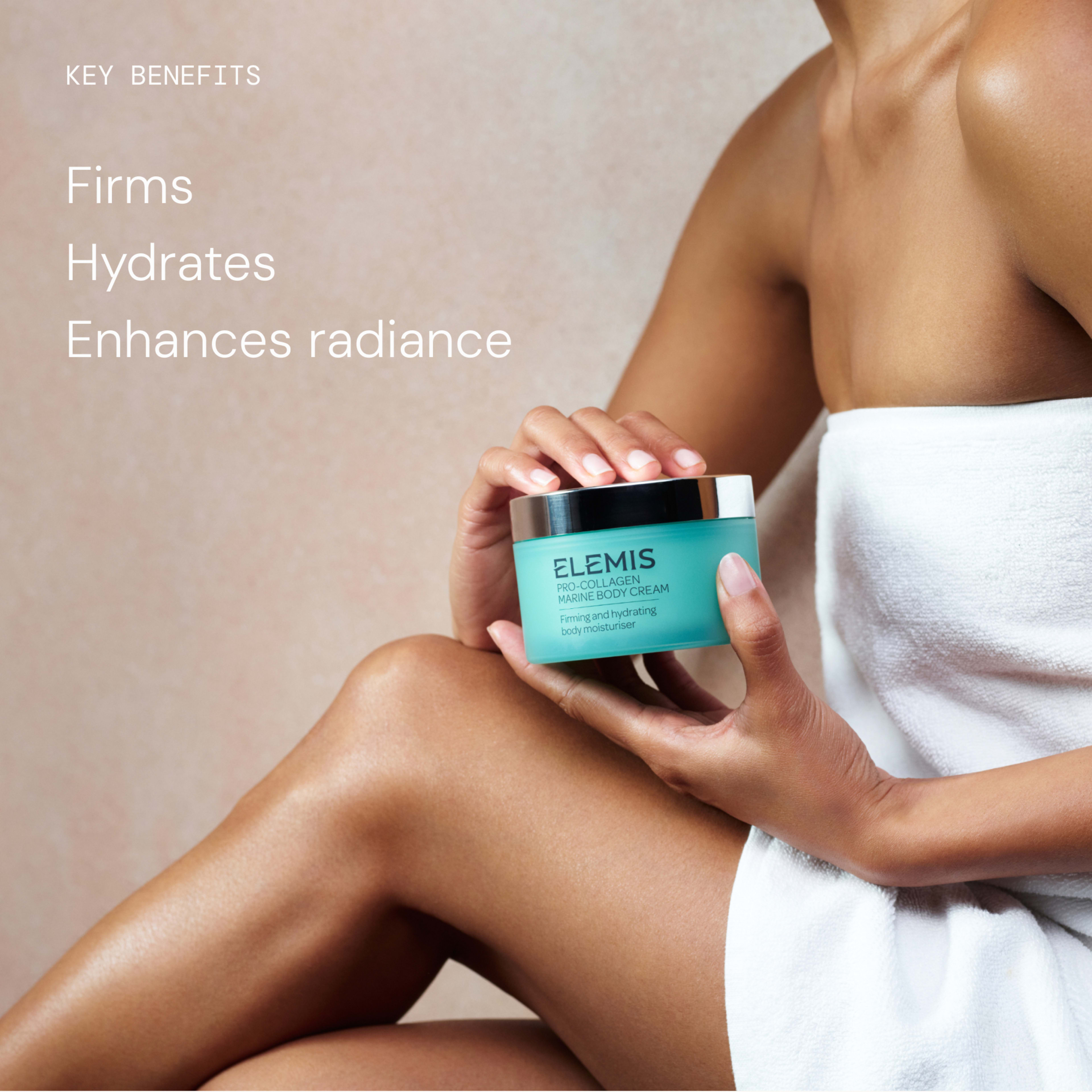 Person in a towel seated against a neutral background, holding an ELEMIS Pro-Collagen Marine Body Cream jar. On the left, text reads: “Key benefits: Firms, Hydrates, Enhances radiance.”