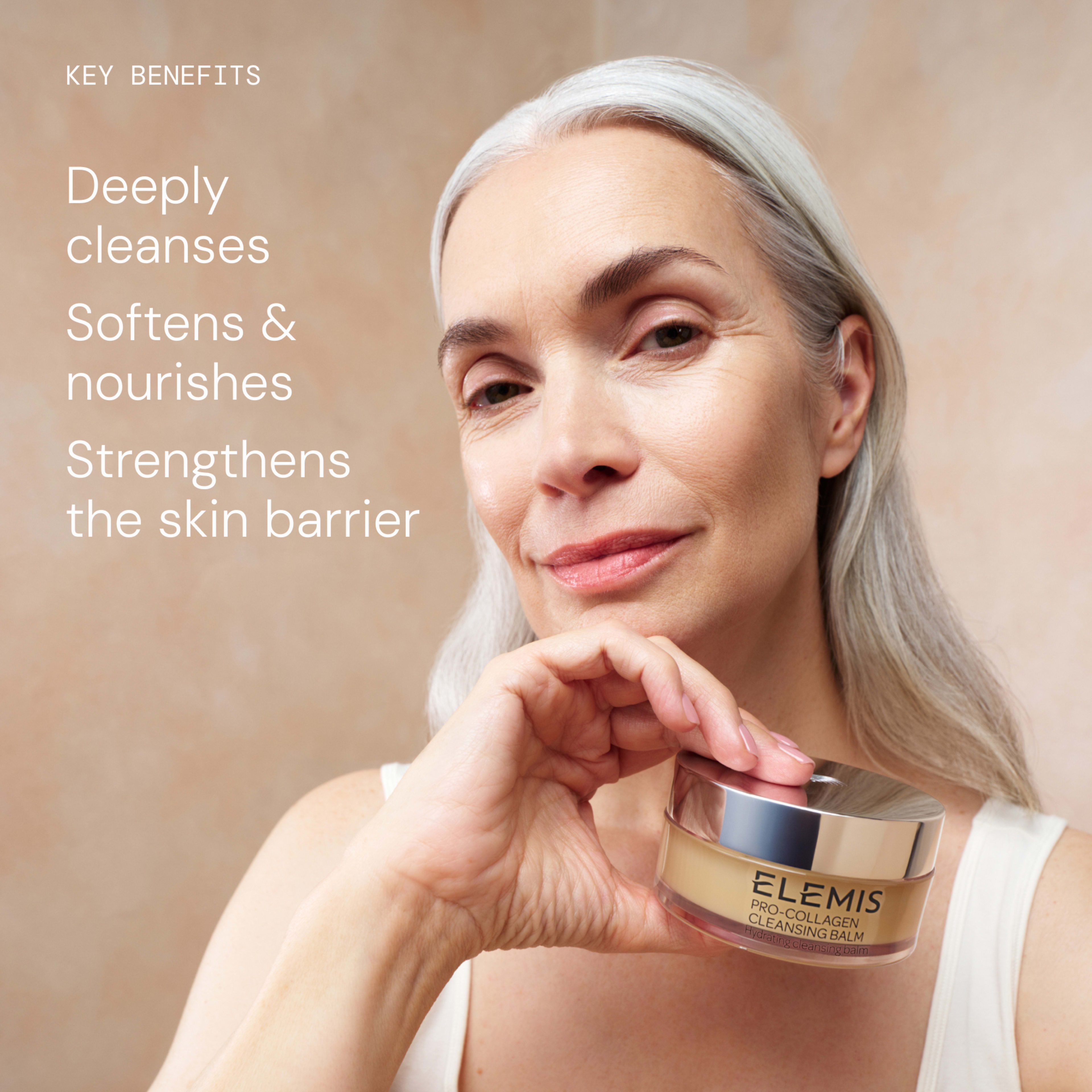 Smiling mature woman with silver hair holds a jar of ELEMIS Pro-Collagen Cleansing Balm against a soft beige background. On the left, text reads: “Key benefits: Deeply cleanses, Softens & nourishes, Strengthens the skin barrier.”
