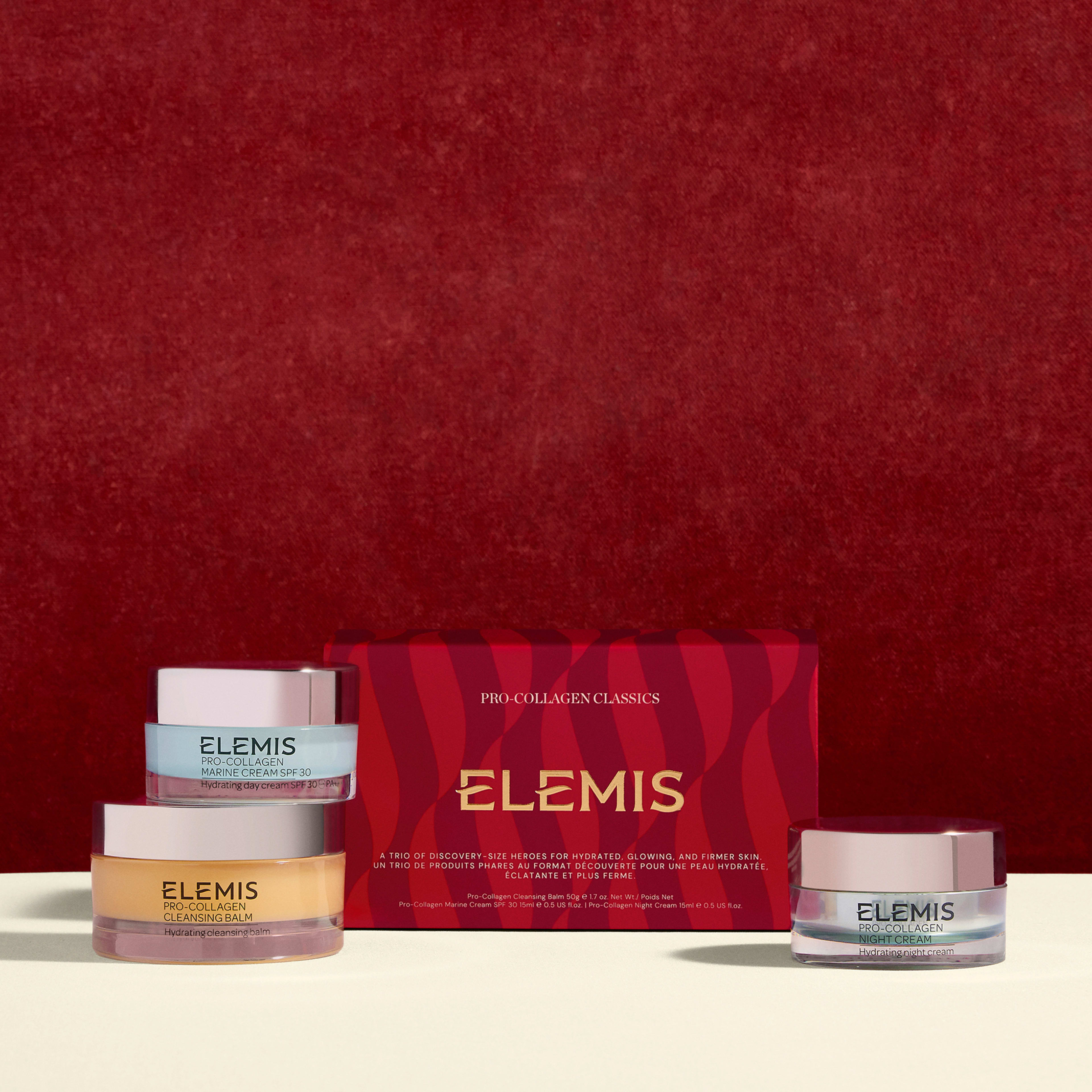 ELEMIS Pro-Collagen Classics gift set against a red background, featuring a red patterned box and three skincare jars, including Pro-Collagen Cleansing Balm, Pro-Collagen Marine Cream SPF30 and Pro-Collagen Night Cream.