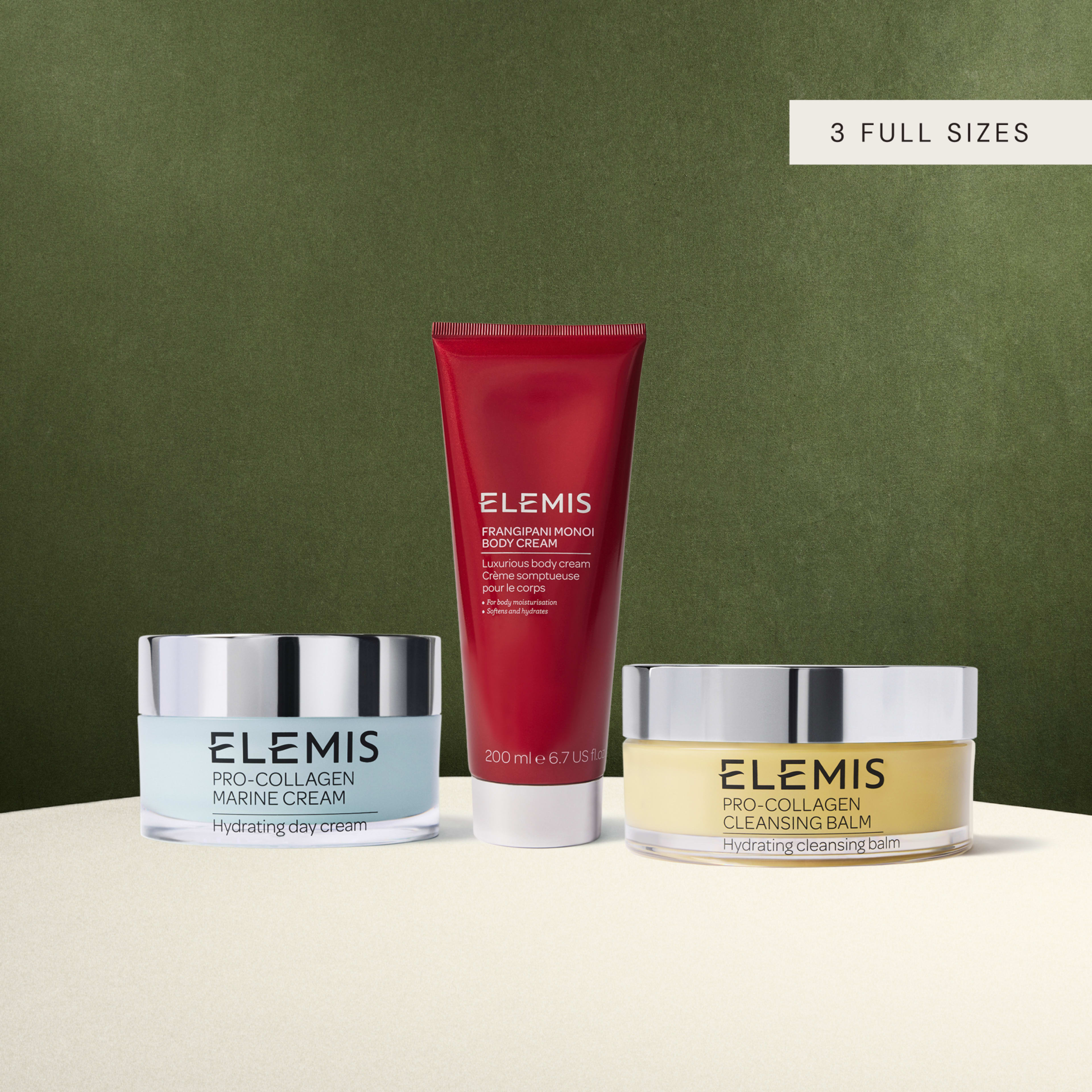 ELEMIS gift set featuring three full-size skincare products: Pro-Collagen Marine Cream hydrating day cream, Frangipani Monoi Body Cream 200ml, and Pro-Collagen Cleansing Balm hydrating cleansing balm, displayed against a green background.