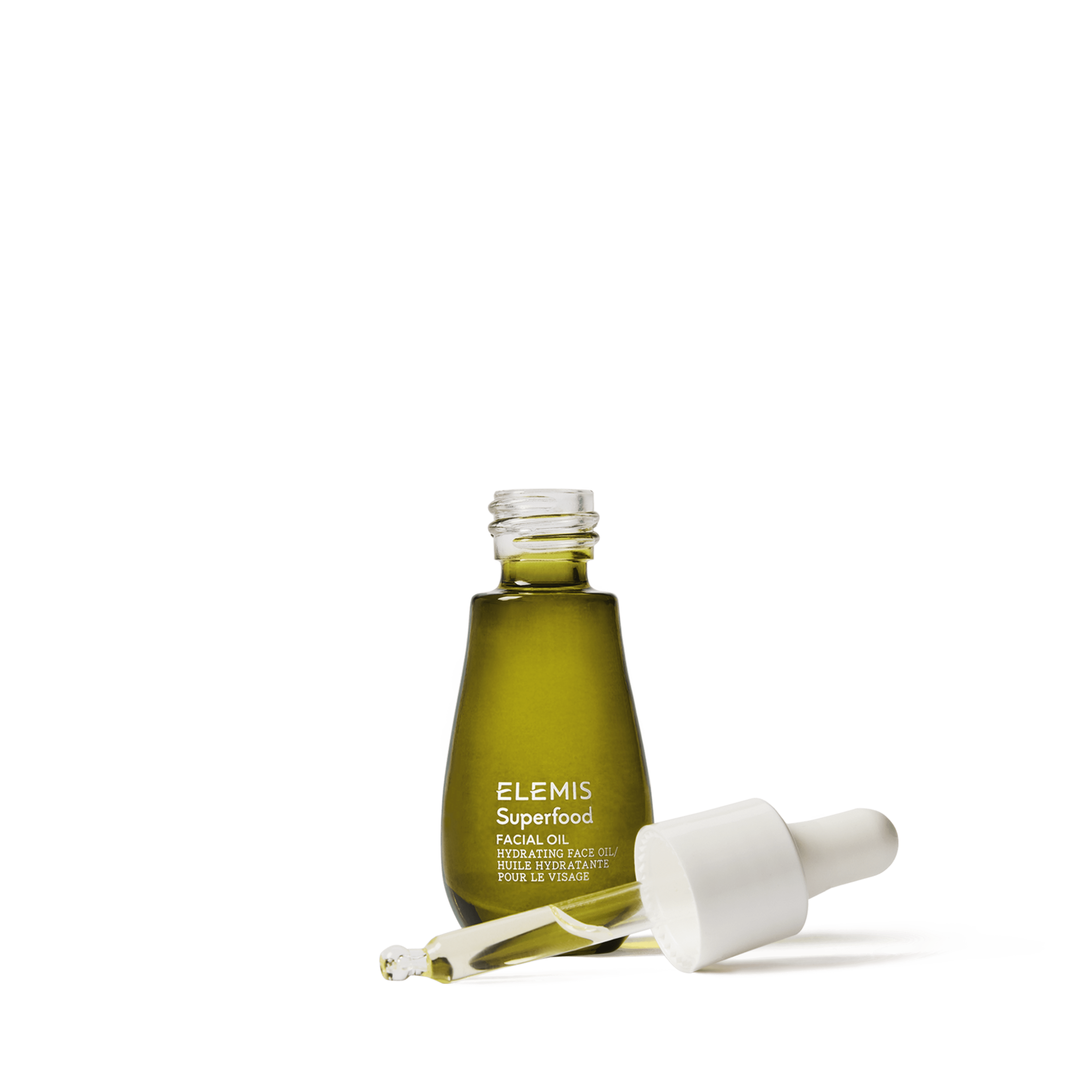 ELEMIS Superfood Facial Oil in a small green glass bottle with white text, shown open with a white dropper and a drop of oil in front, on a white background.