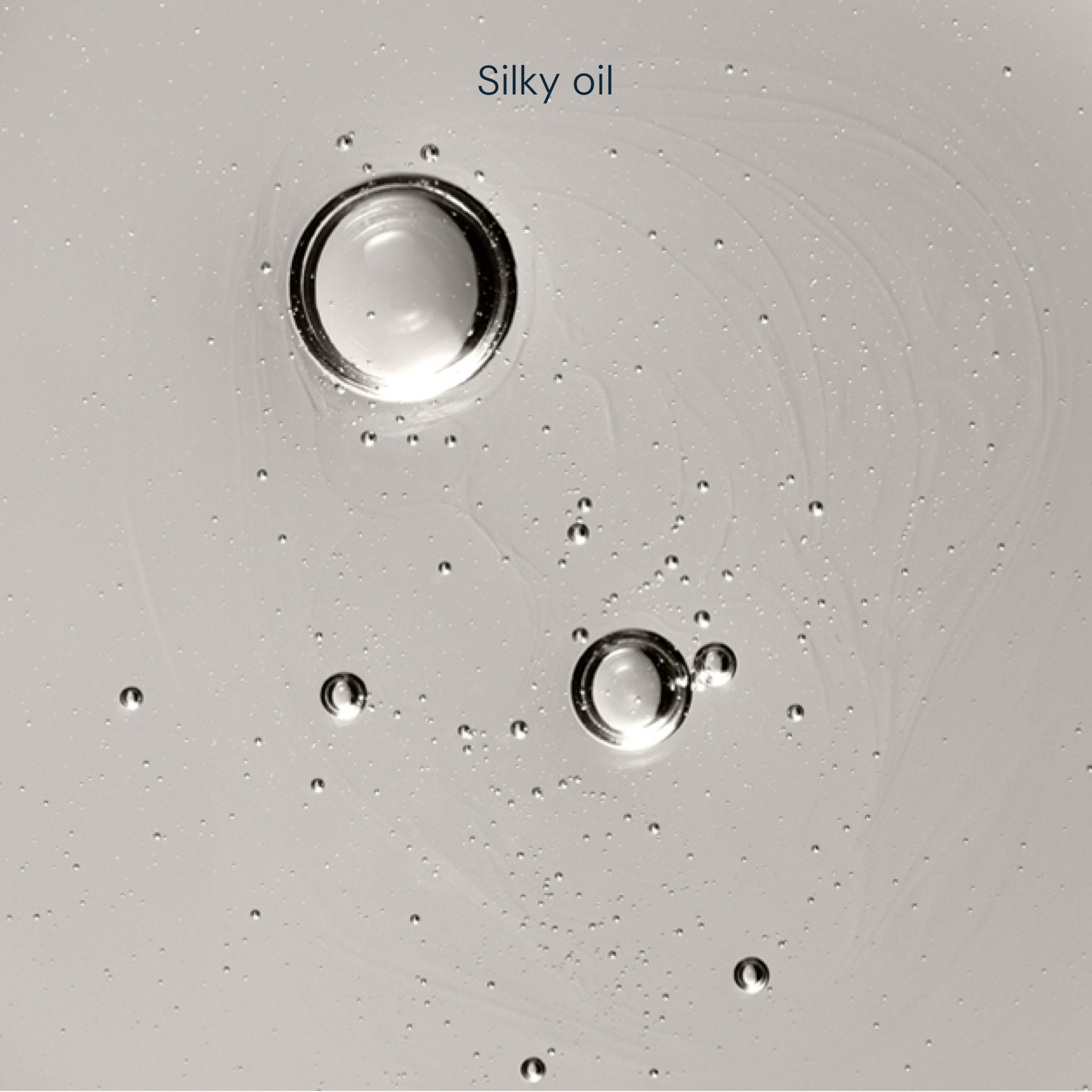Clear liquid background with floating translucent bubbles and the words “Silky oil” at the top.