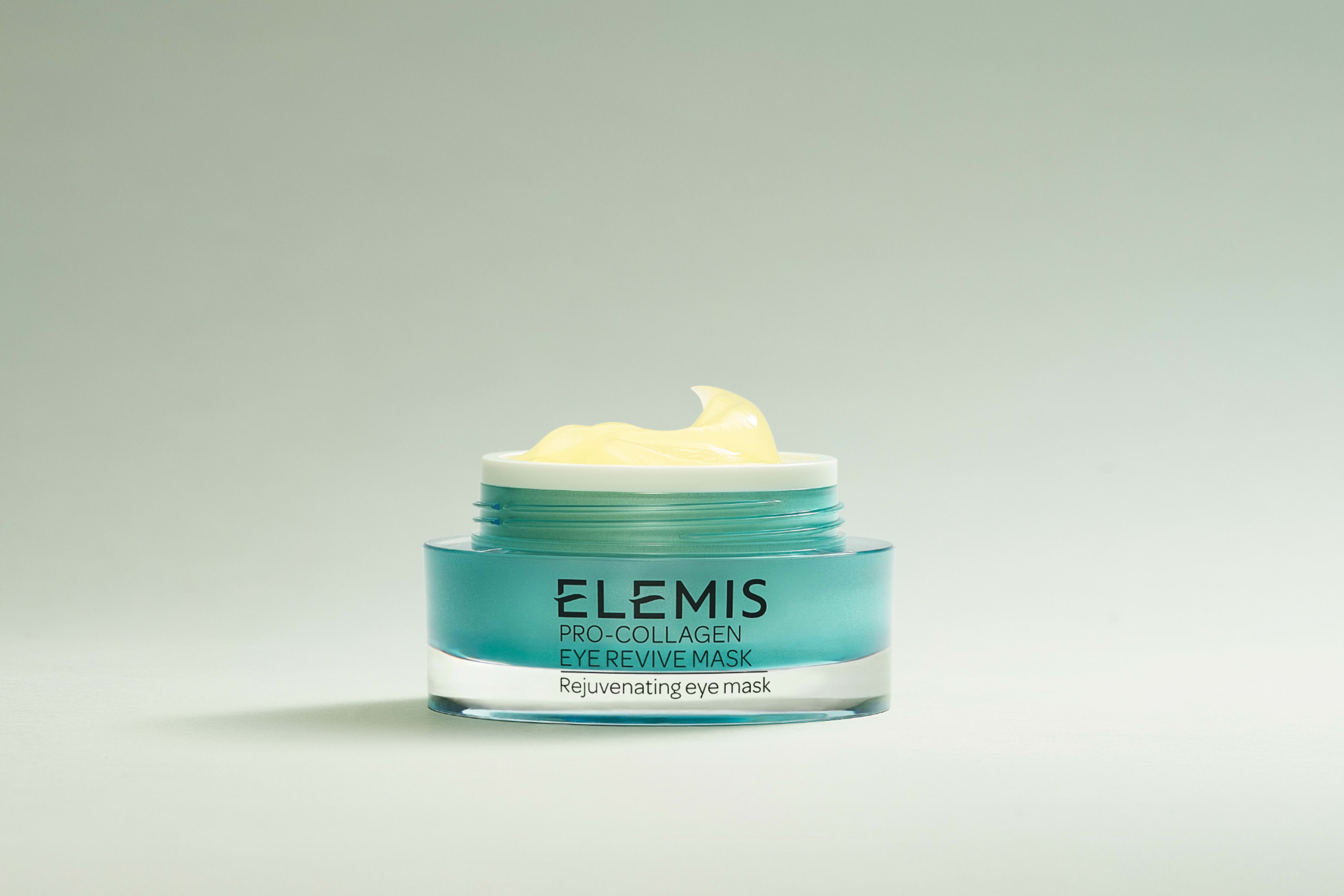 Two teal and silver Elemis Pro-Collagen eye products, an eye mask and an eye cream, sit in splashing water.