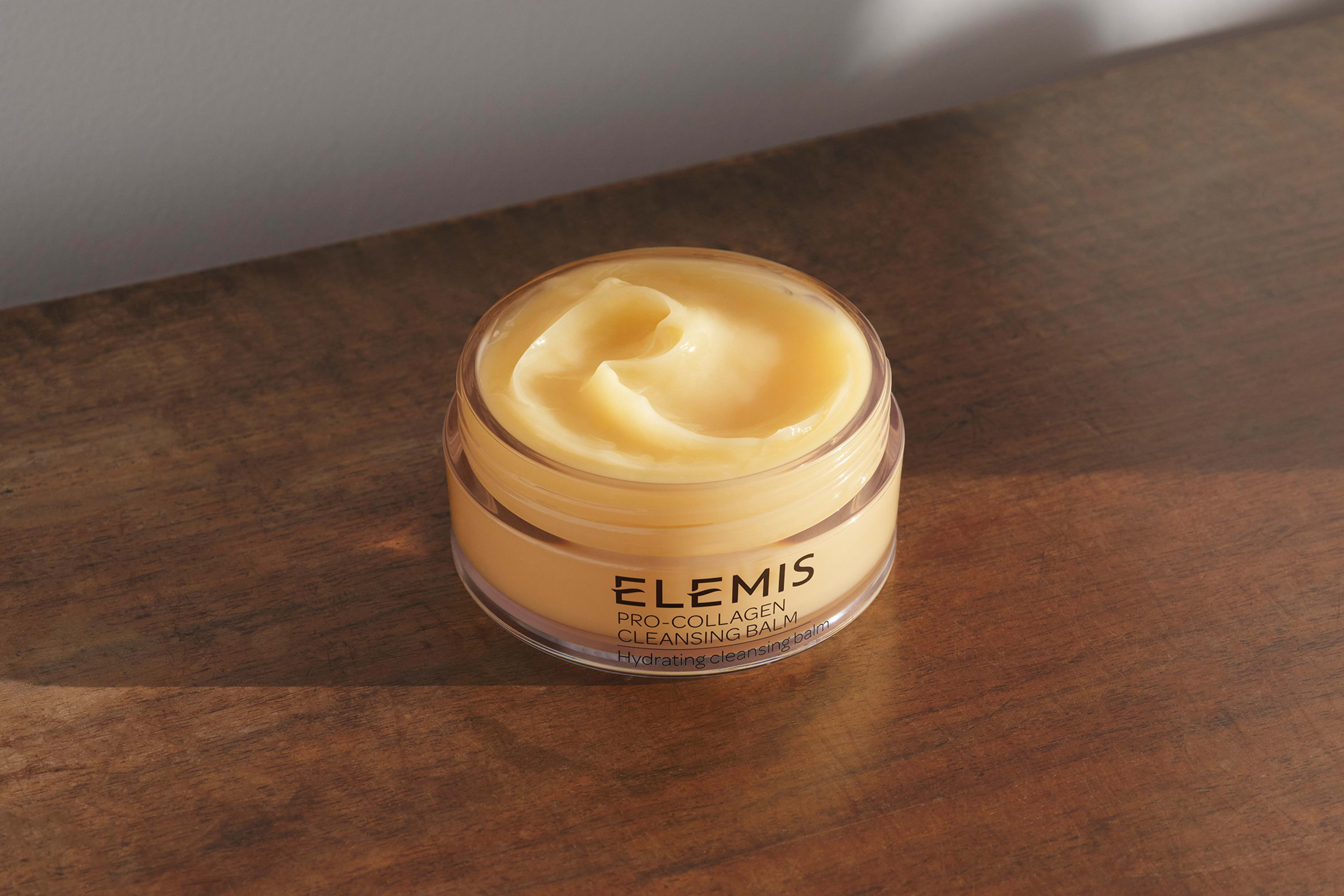 Cleansing Balm with the lid open sitting on a wooden table